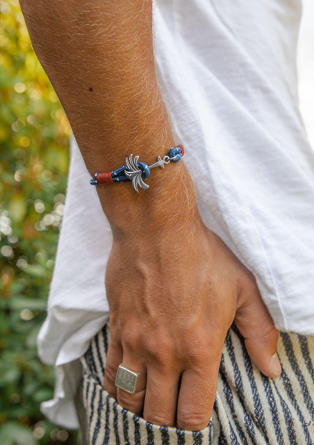 Voyager Palm Band featuring a silver palm tree anchor on a blue and red nylon rope, symbolizing adventure and happiness.