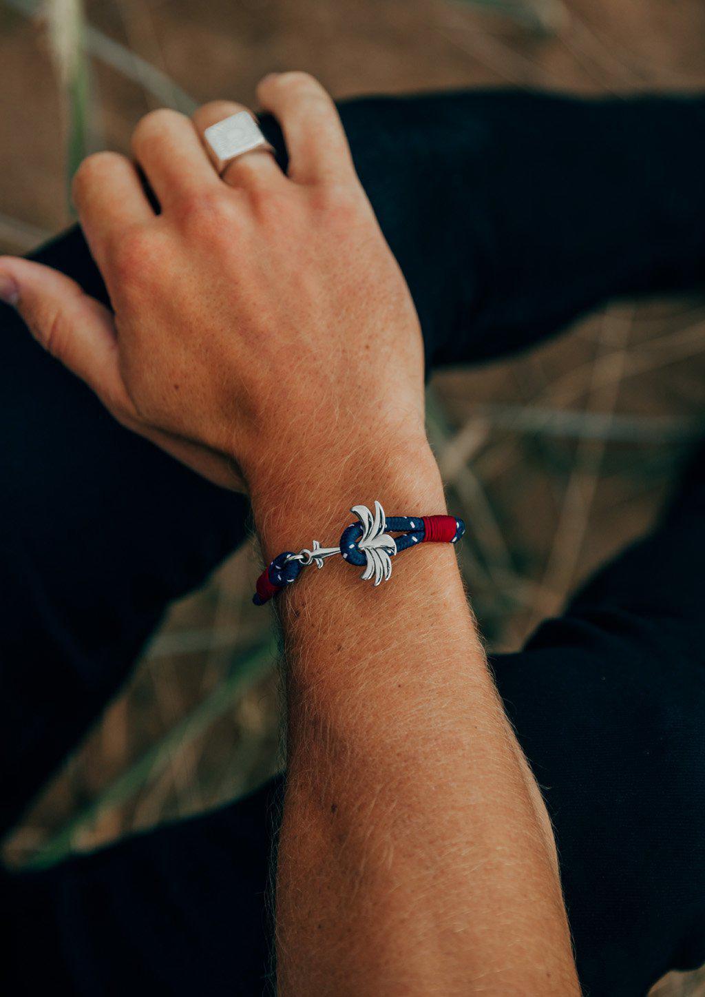 Voyager Palm Band featuring a silver palm tree anchor on a blue and red nylon rope, symbolizing adventure and happiness.