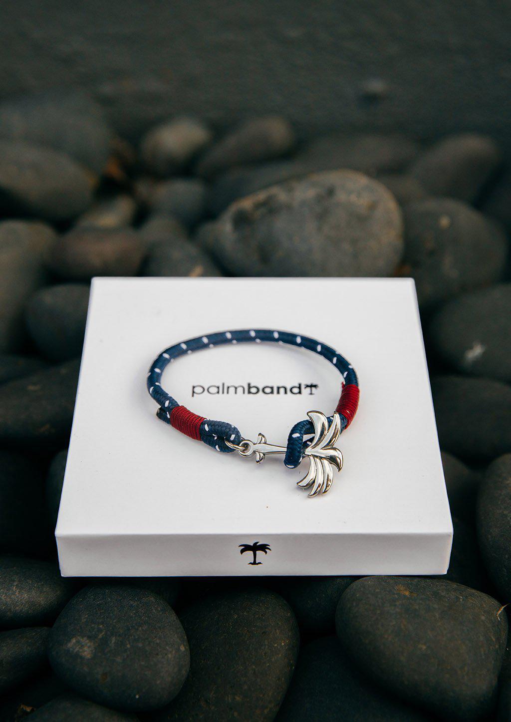 Voyager Palm Band featuring a silver palm tree anchor on a blue and red nylon rope, symbolizing adventure and happiness.