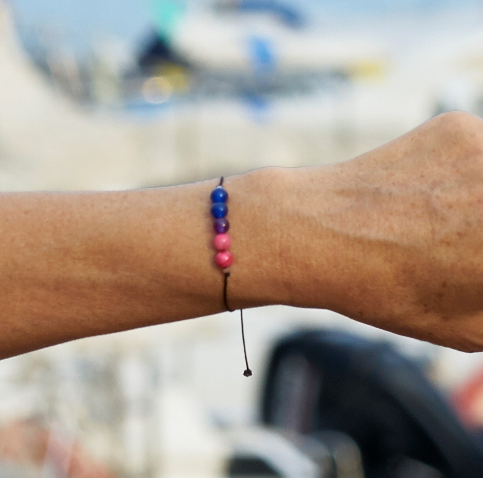 Pulsera de orgullo bisexual hecha a mano con ágatas naturales en colores fucsia, violeta y azul, ajustable con hilo negro.