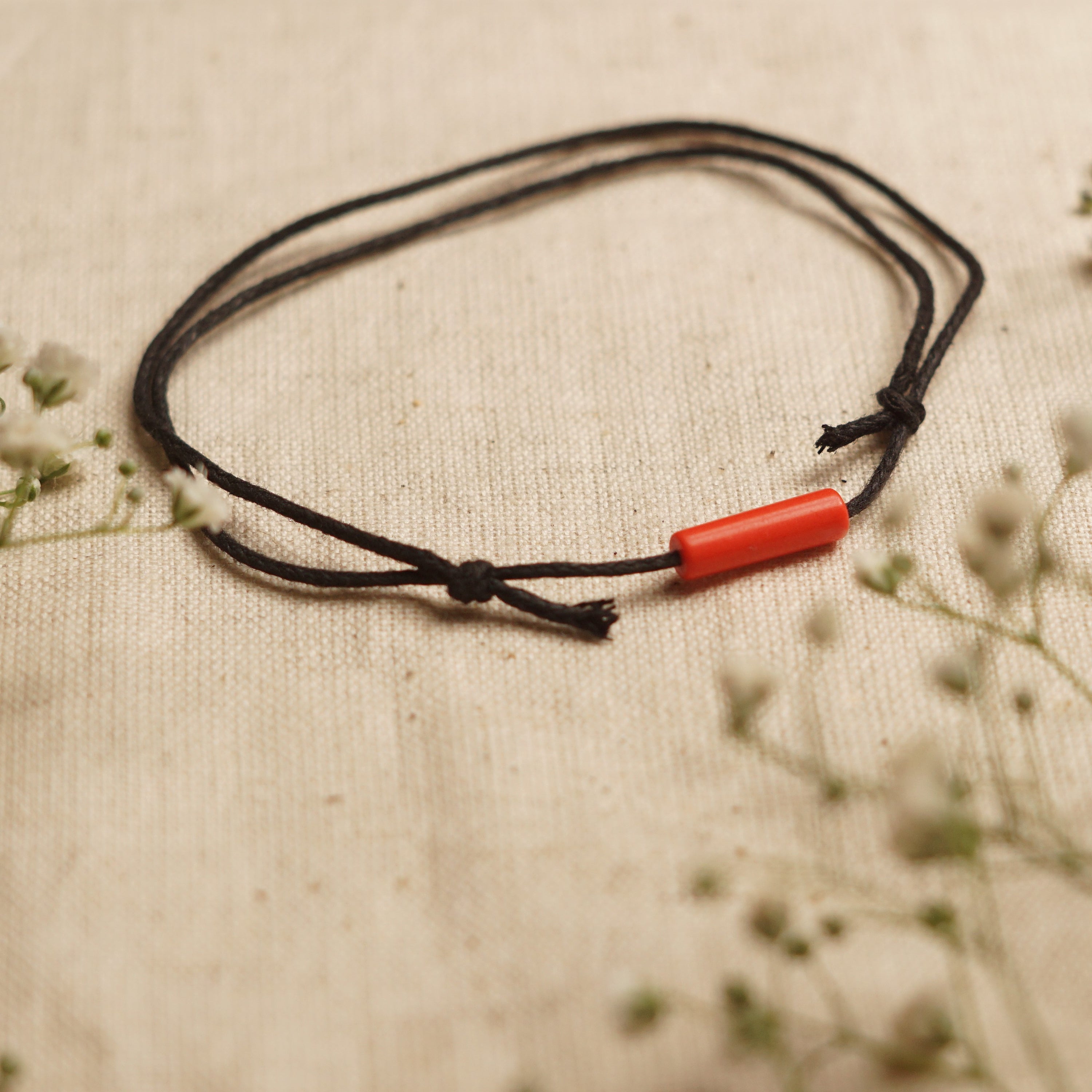 Red Coral Bar Minimal and Adjustable anklet made with waxed cotton cord, featuring a sliding knot for adjustable fit.