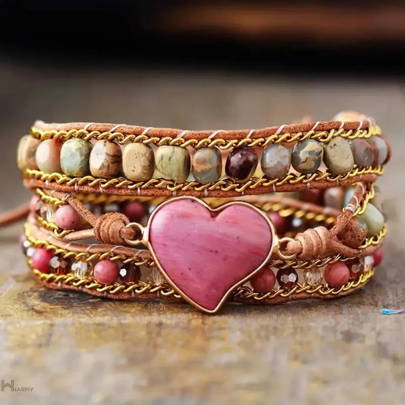 A beautifully crafted Rhodonite Heart Wrap Bracelet featuring natural stones and red wood grain beads, showcasing a love heart design.