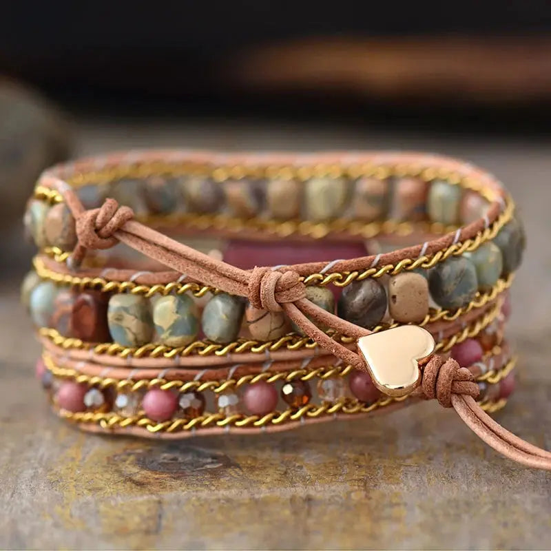 A beautifully crafted Rhodonite Heart Wrap Bracelet featuring natural stones and red wood grain beads, showcasing a love heart design.