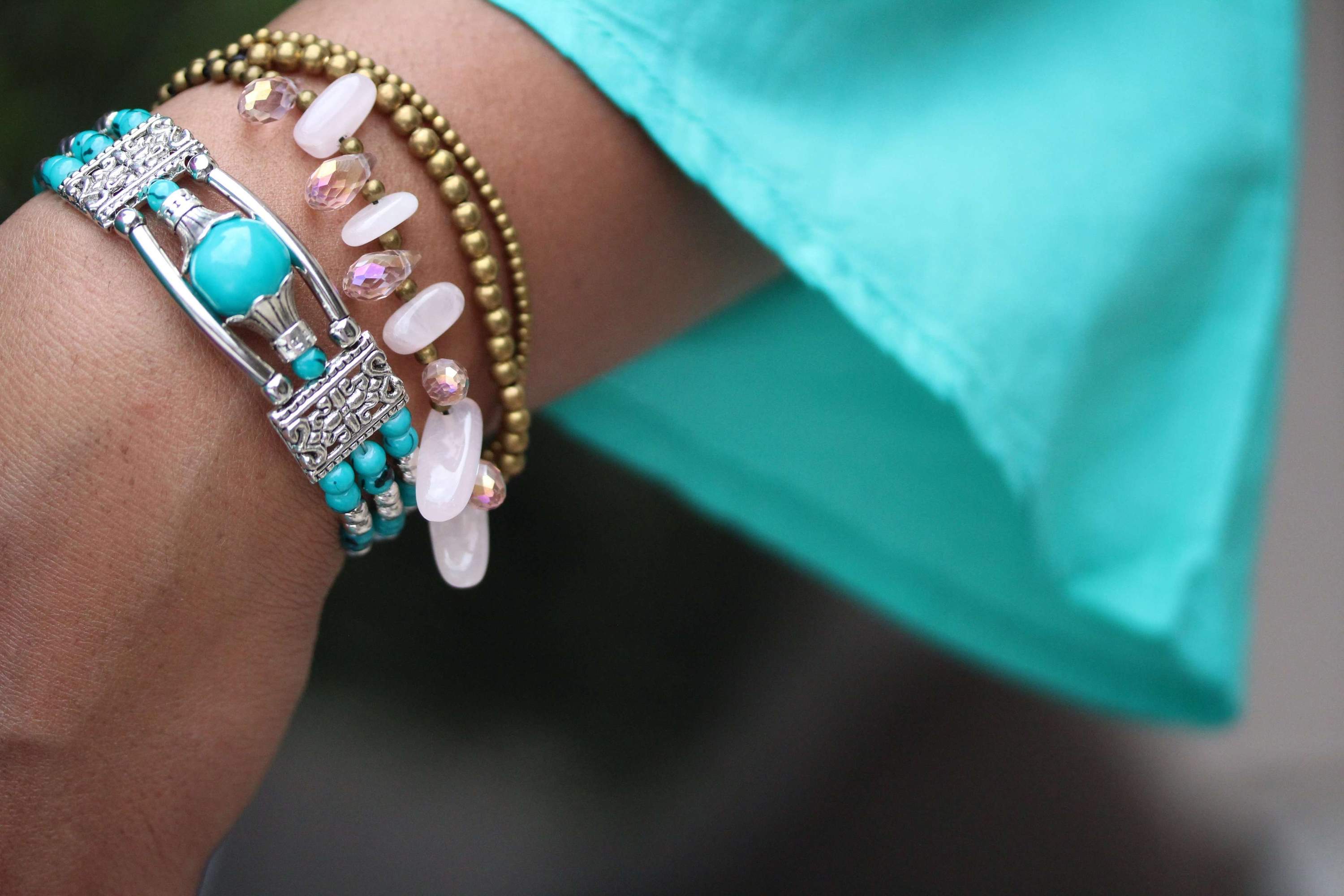 Rose Quartz & Crystals Romance Bracelet featuring soft pink crystals and brass bell drops on a black chord.