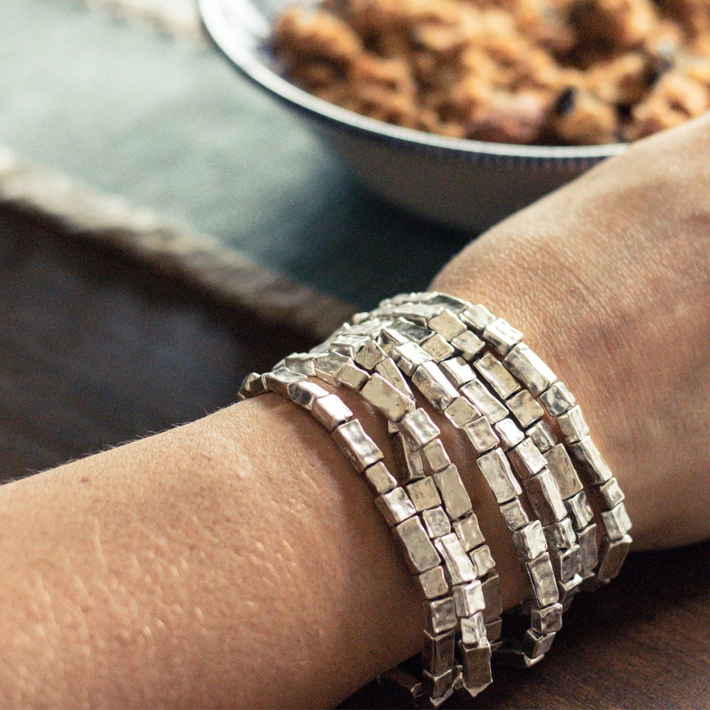 A stylish set of 7 elongated bead bracelets featuring rectangular and square beads in gold, silver, and rose gold plating, elegantly stacked together.