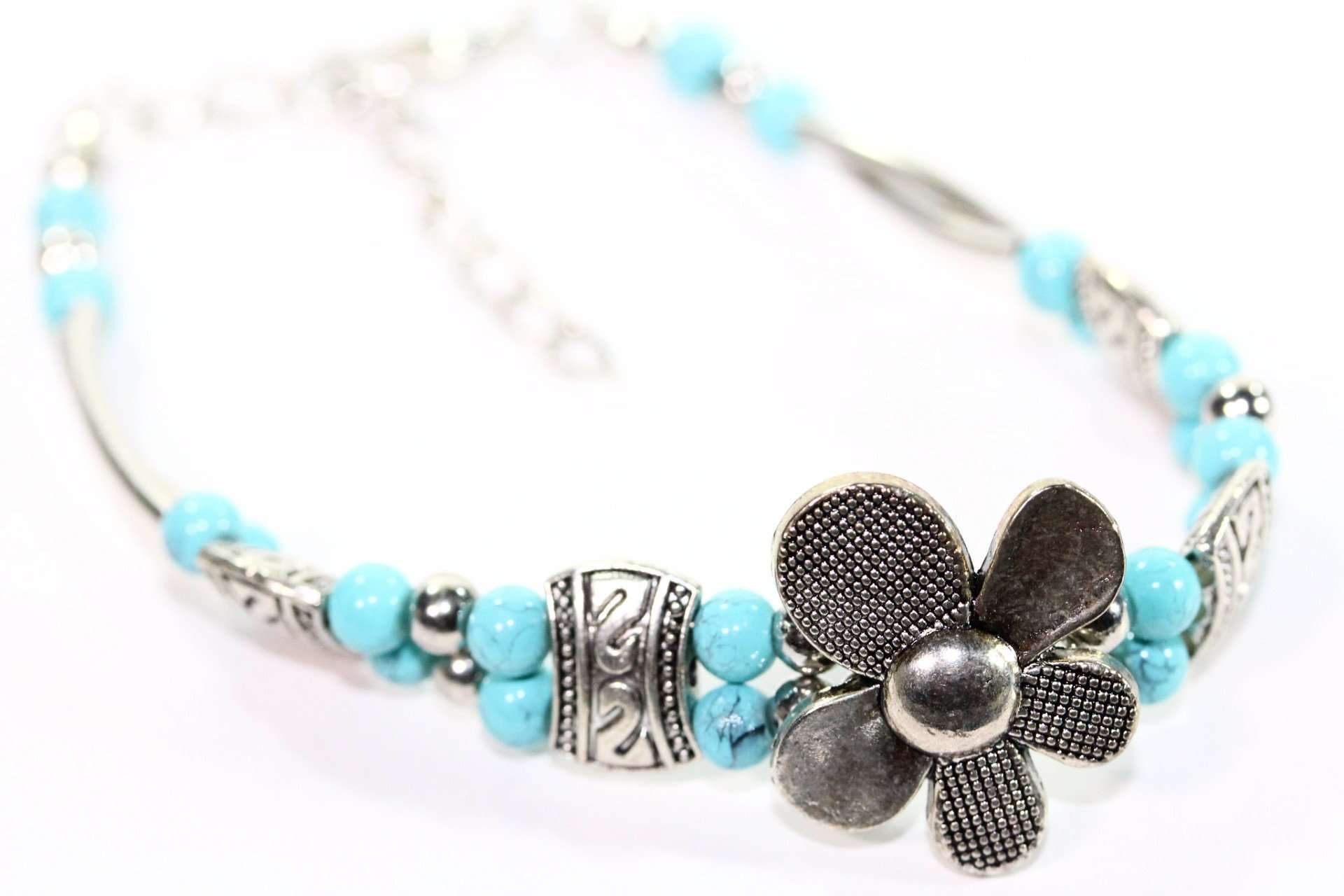 A beautiful Silver Petal Flowers Bracelet featuring turquoise accents and silver tone beads, showcasing intricate flower designs.