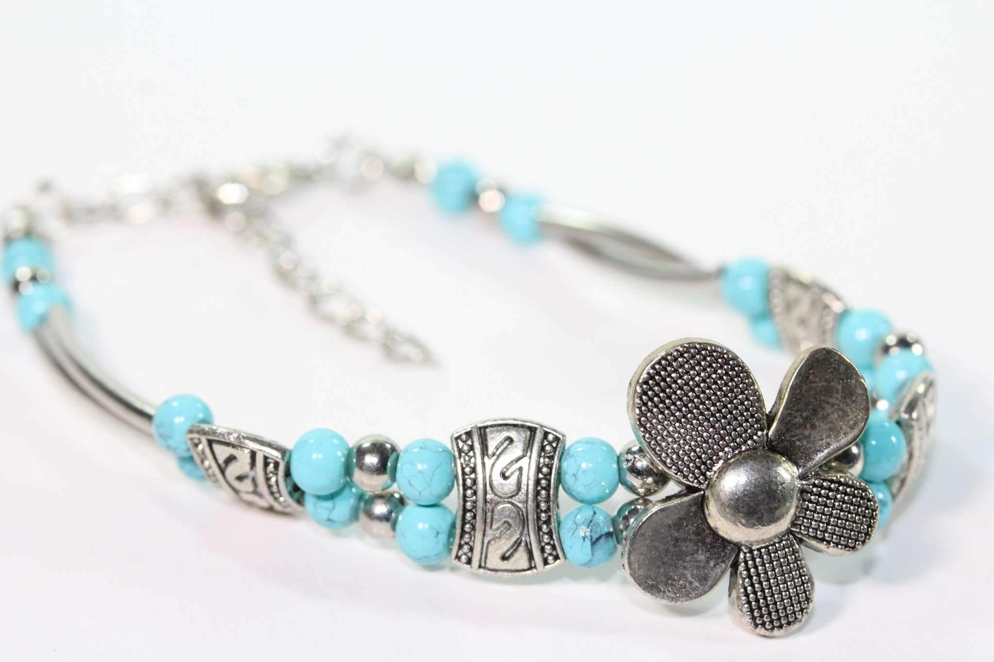 A beautiful Silver Petal Flowers Bracelet featuring turquoise accents and silver tone beads, showcasing intricate flower designs.