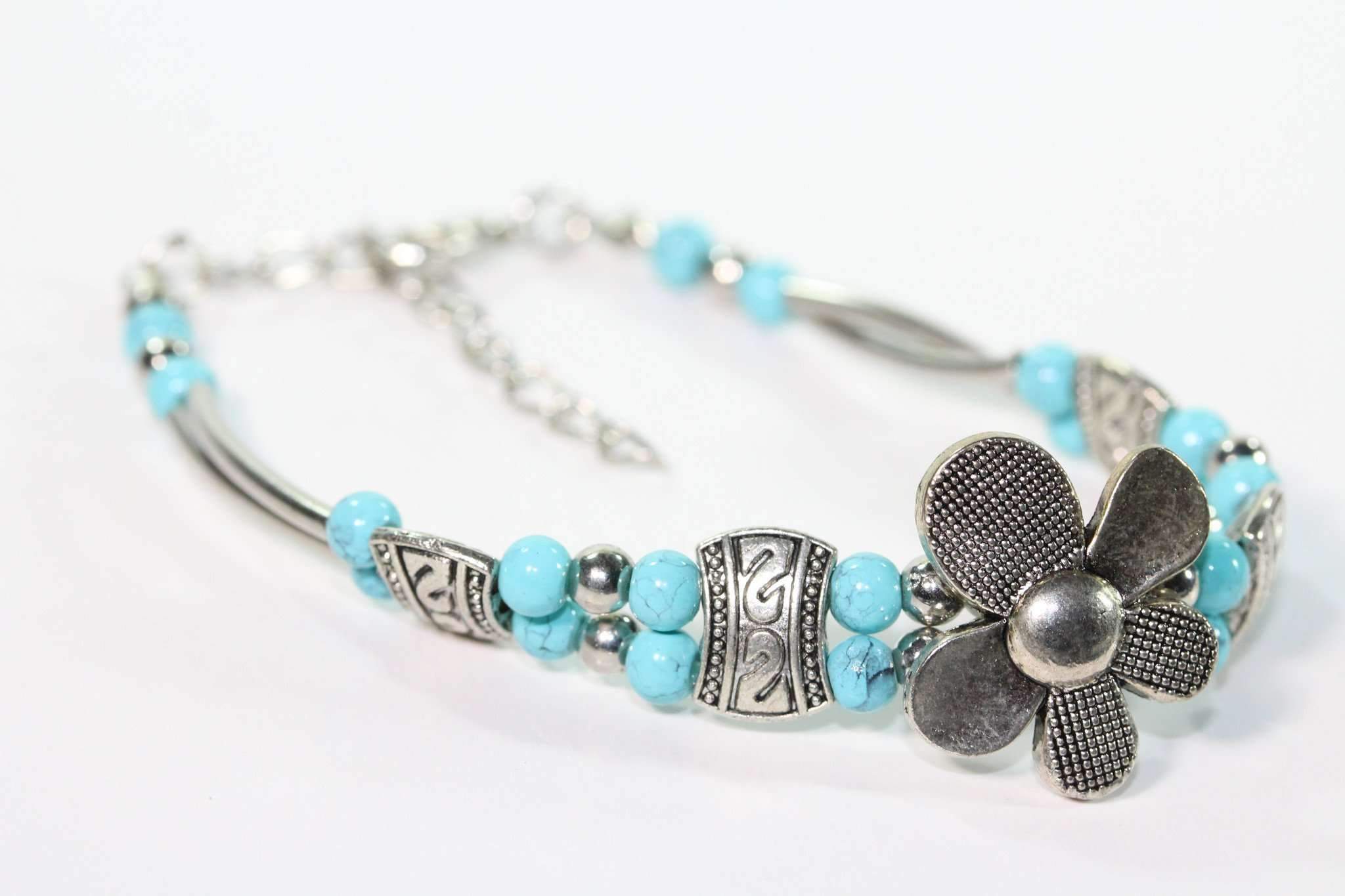 A beautiful Silver Petal Flowers Bracelet featuring turquoise accents and silver tone beads, showcasing intricate flower designs.