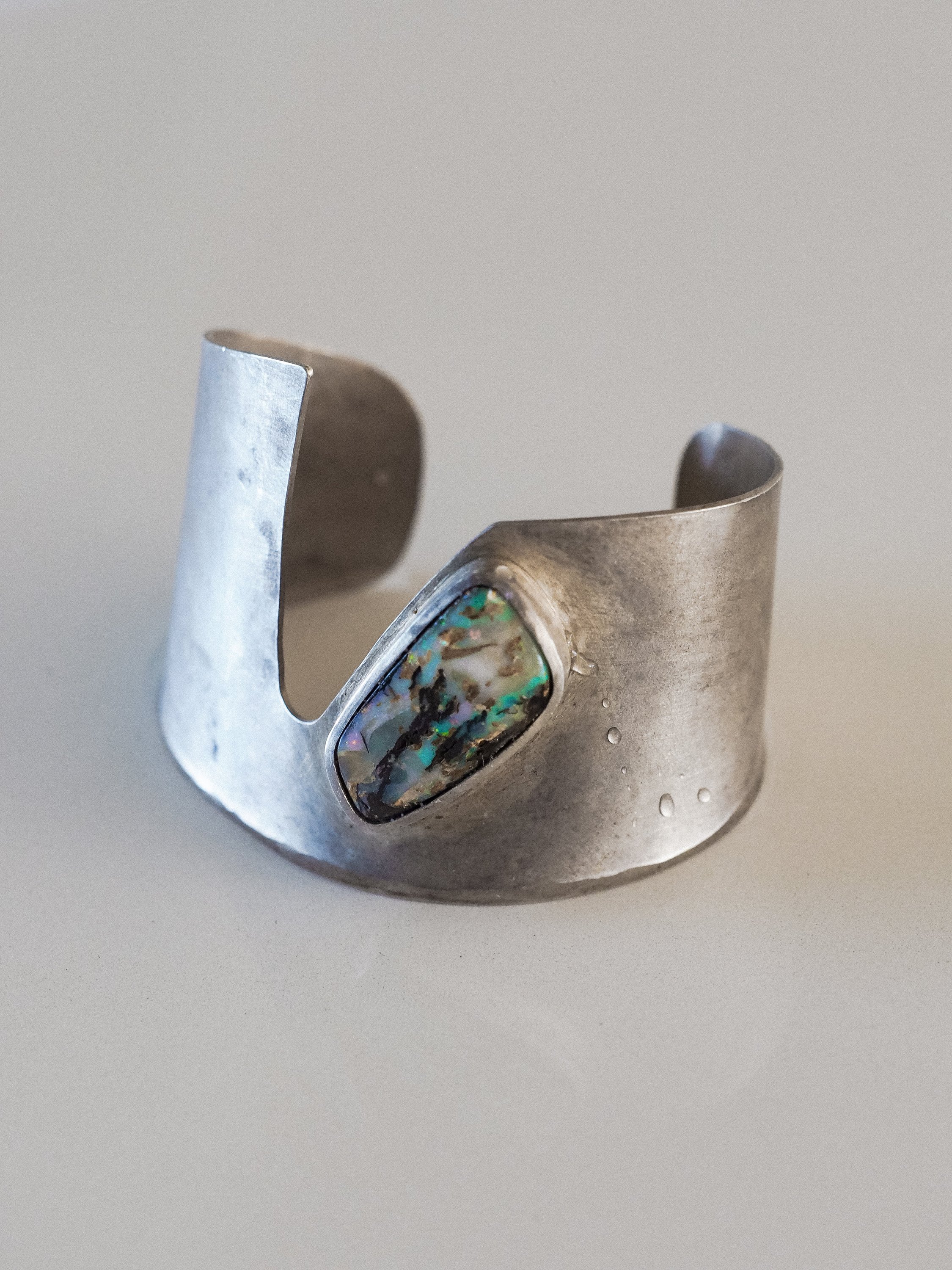 A stunning handmade cuff featuring turquoise and purple Boulder Opal set in high-quality Indian sterling silver.