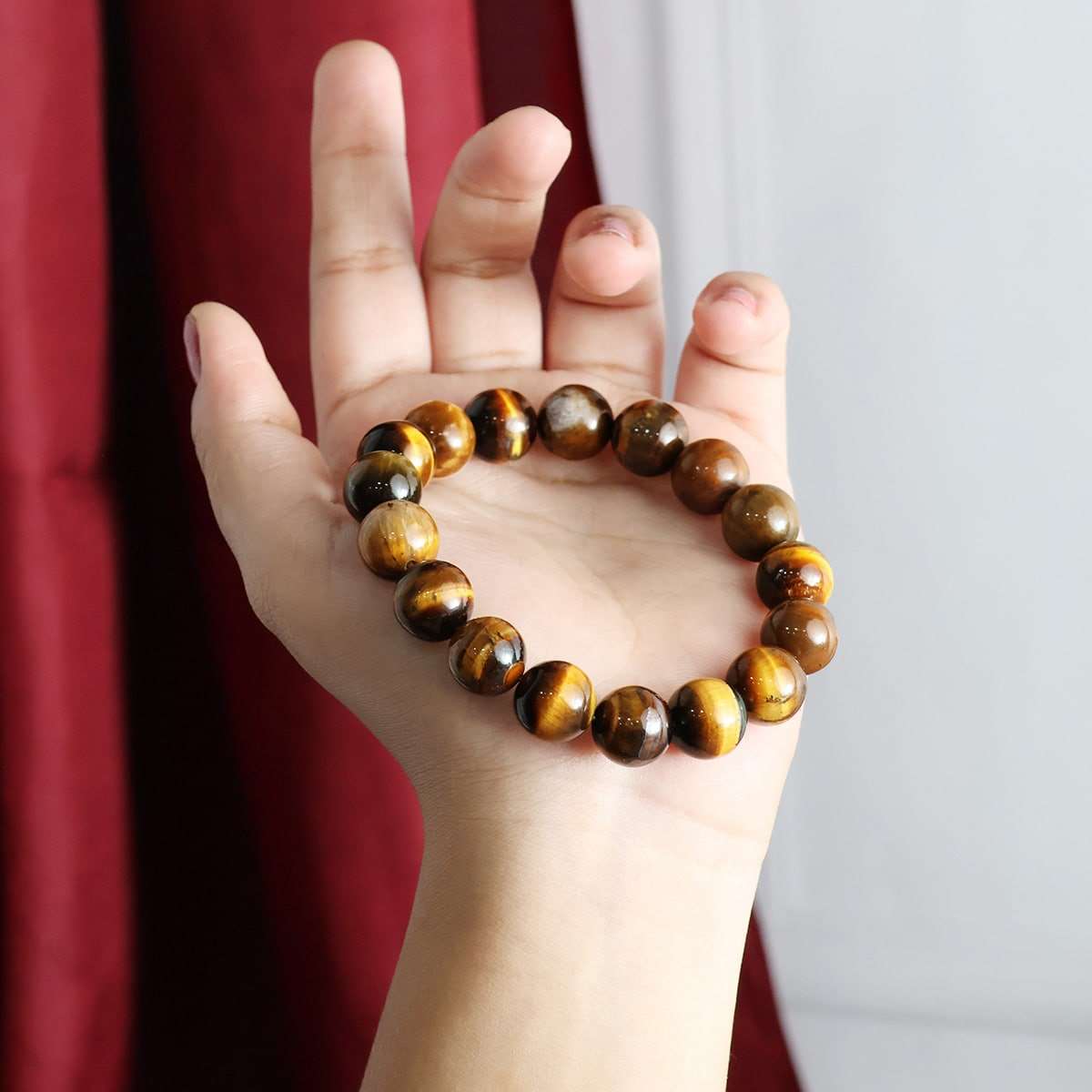 A close-up view of a Tiger Eye Round Beads Bracelet showcasing its natural golden-brown hues and round beads, elegantly strung on elastic.