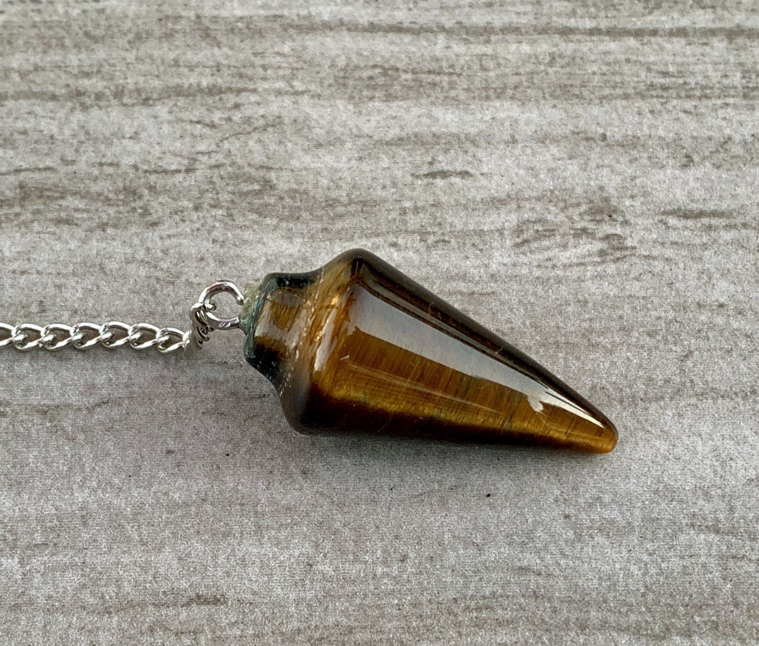 Tigers Eye Dowsing Pendulum and Bracelet showcasing golden yellow and deep yellow-brown hues with black stripes, symbolizing strength and grounding.