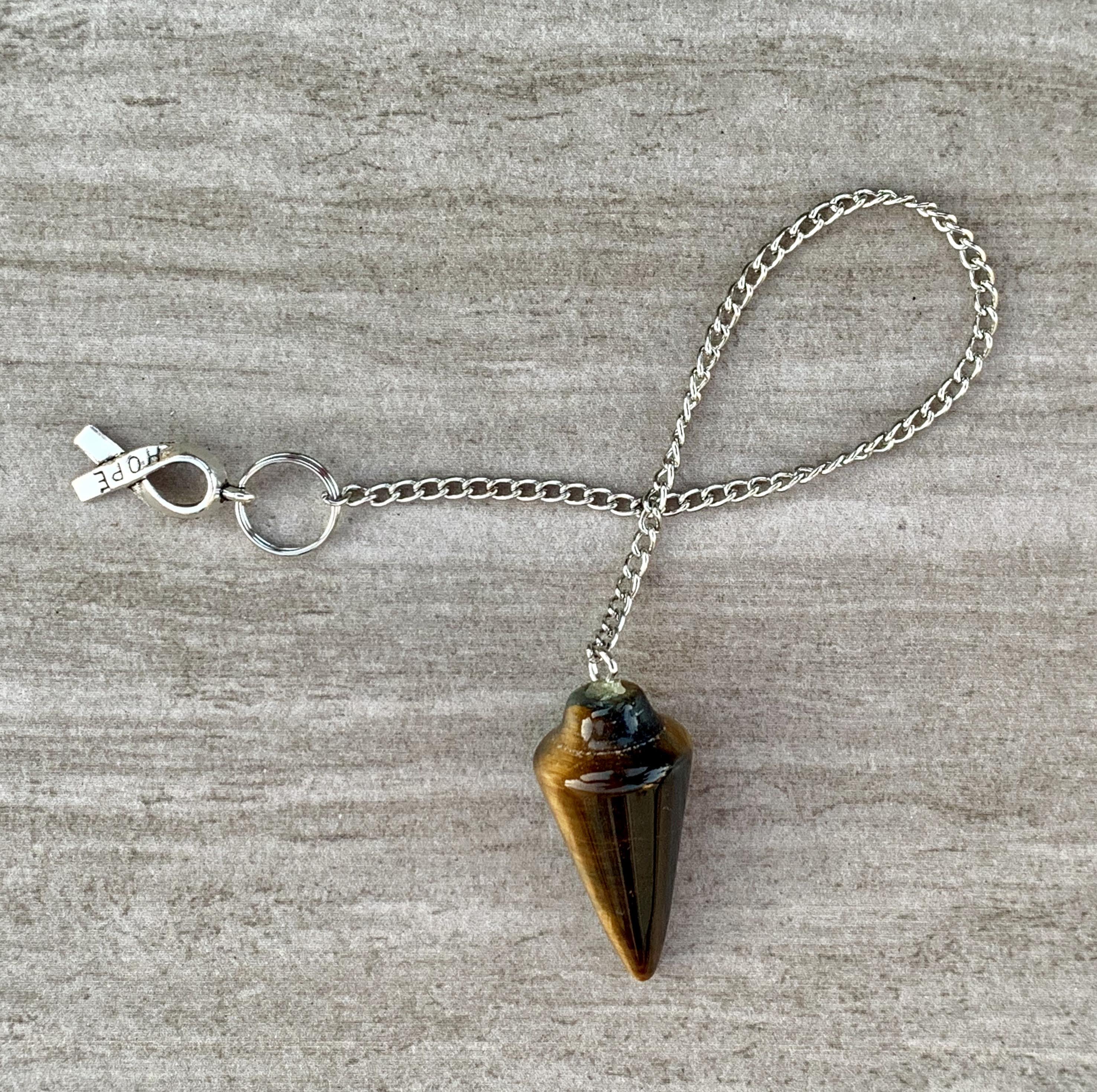 Tigers Eye Dowsing Pendulum and Bracelet showcasing golden yellow and deep yellow-brown hues with black stripes, symbolizing strength and grounding.