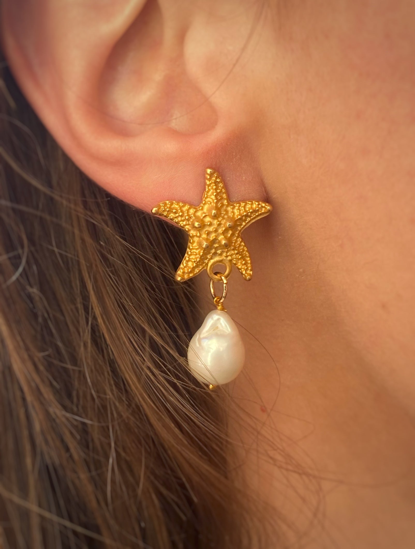 Handcrafted APHRODITE'S STAR EARRINGS featuring a golden starfish and baroque pearl, inspired by Sicilian beauty.