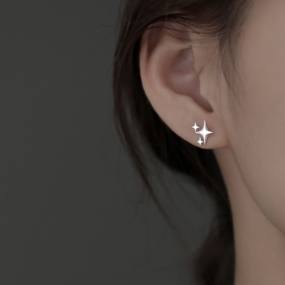 A pair of Asymmetrical Star Stud Earrings in gold and silver, showcasing a modern design with a smooth finish.