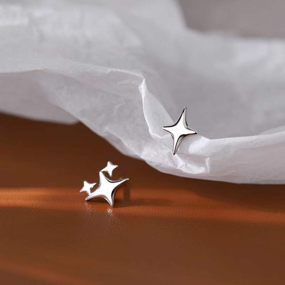 A pair of Asymmetrical Star Stud Earrings in gold and silver, showcasing a modern design with a smooth finish.