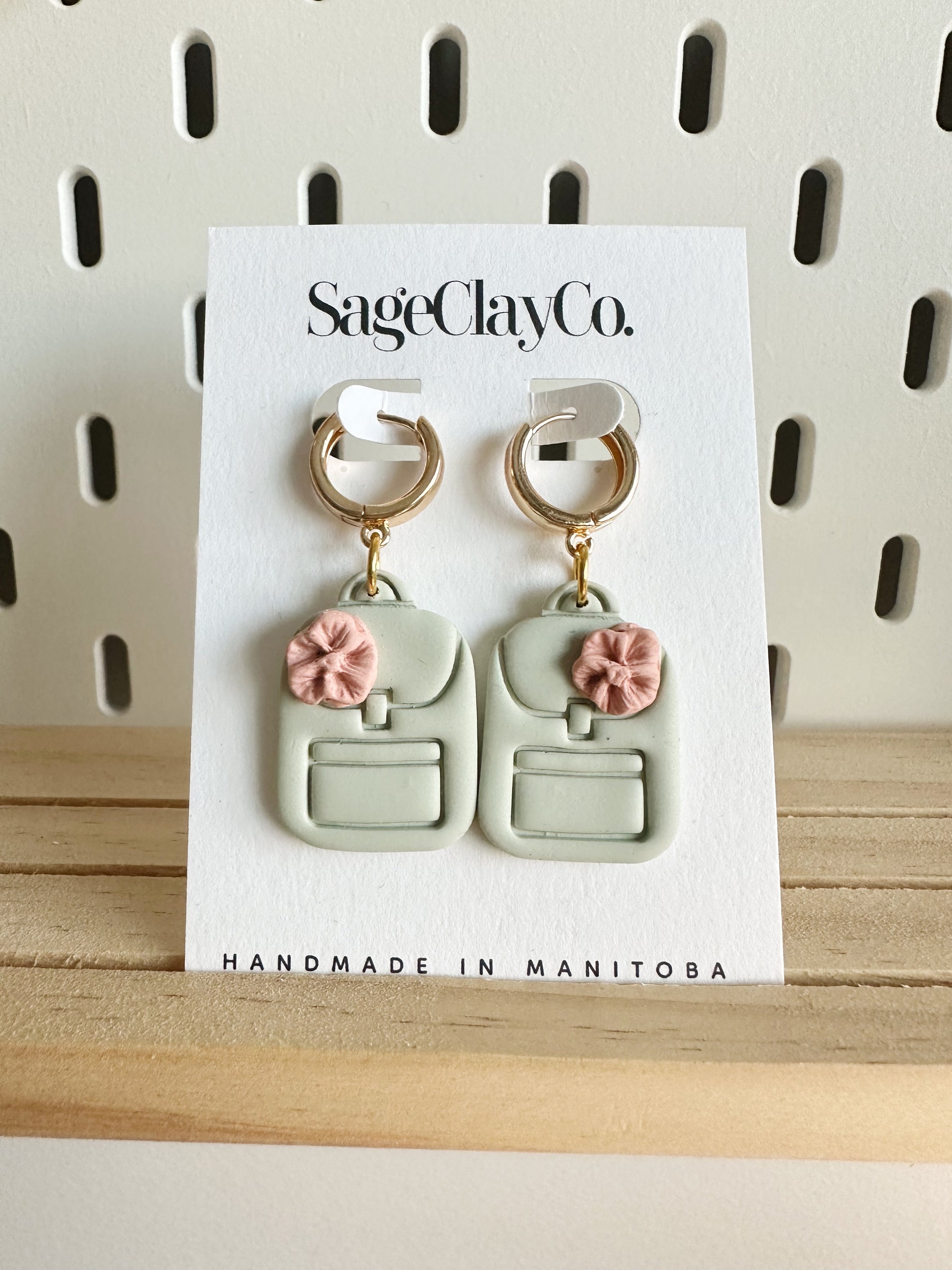 Handmade polymer clay earrings in a minimalist design, featuring a unique backpack theme, perfect for teachers.