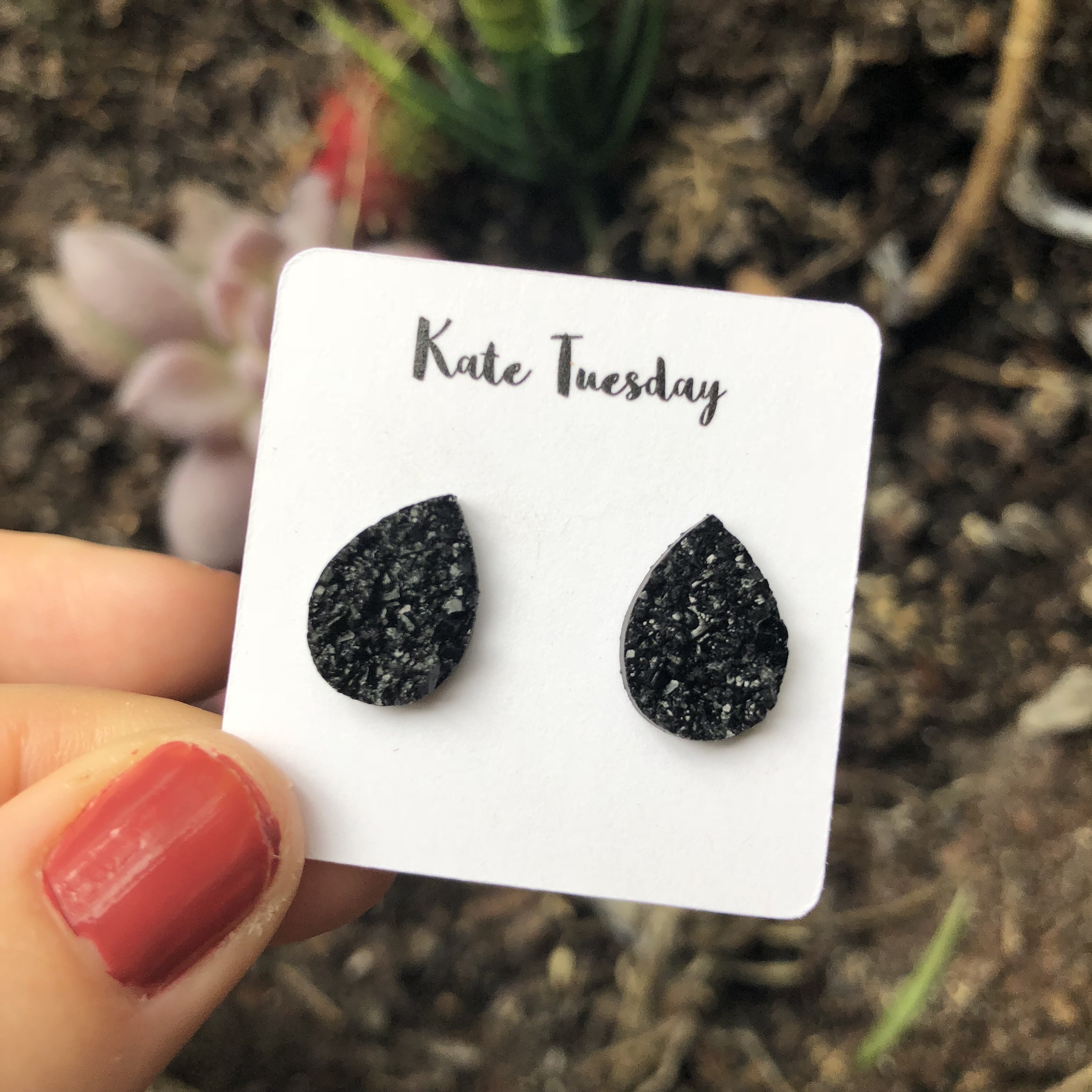 Black teardrop glitter stud earrings.