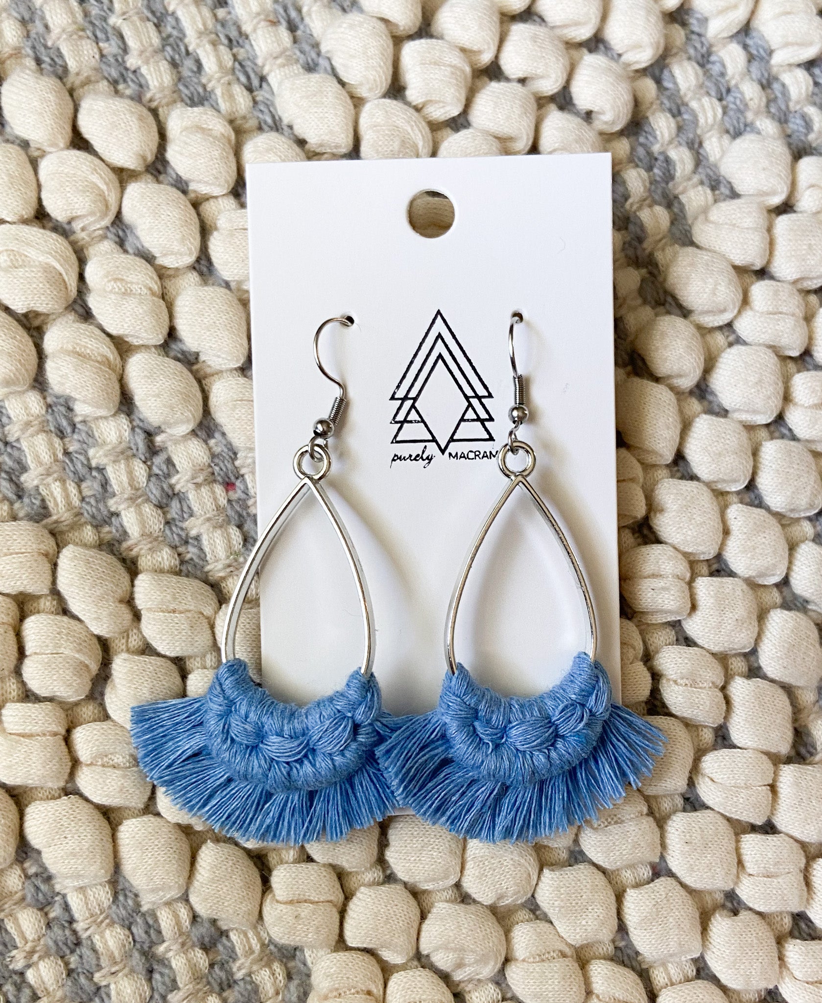 A pair of lightweight blue teardrop earrings made from 100% macrame cotton, showcasing their elegant design.