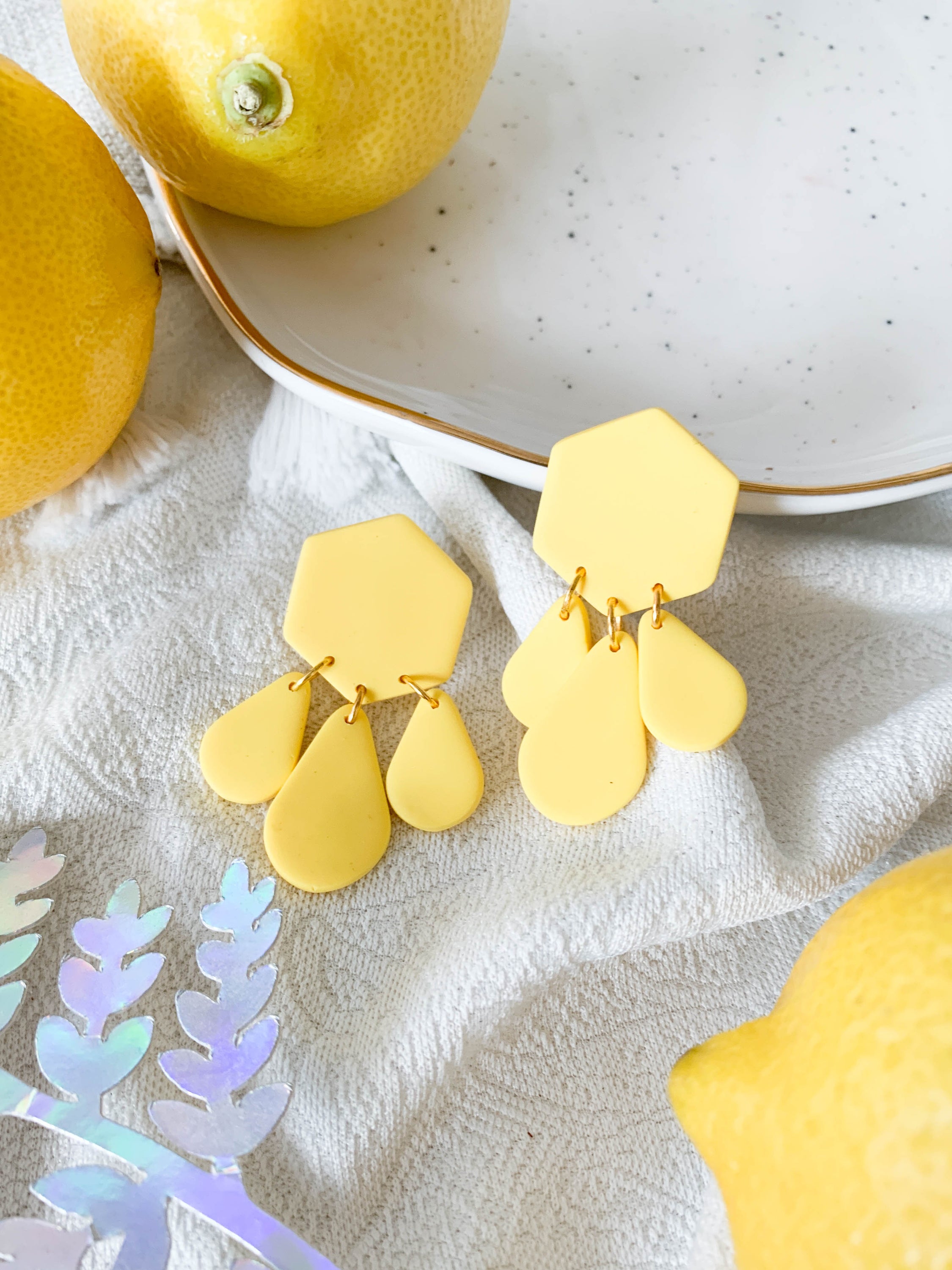 Bridget Lemon earrings featuring a hexagon teardrop design in vibrant yellow, perfect for adding a cheerful touch to any outfit.