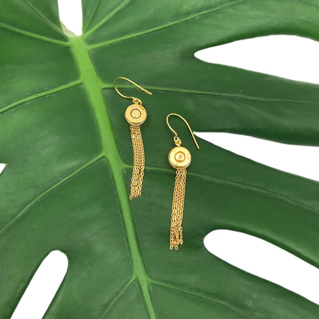 A pair of handmade Bullet Tassel Earrings featuring recycled brass bullet casings and gold-plated chains, showcasing their unique design.