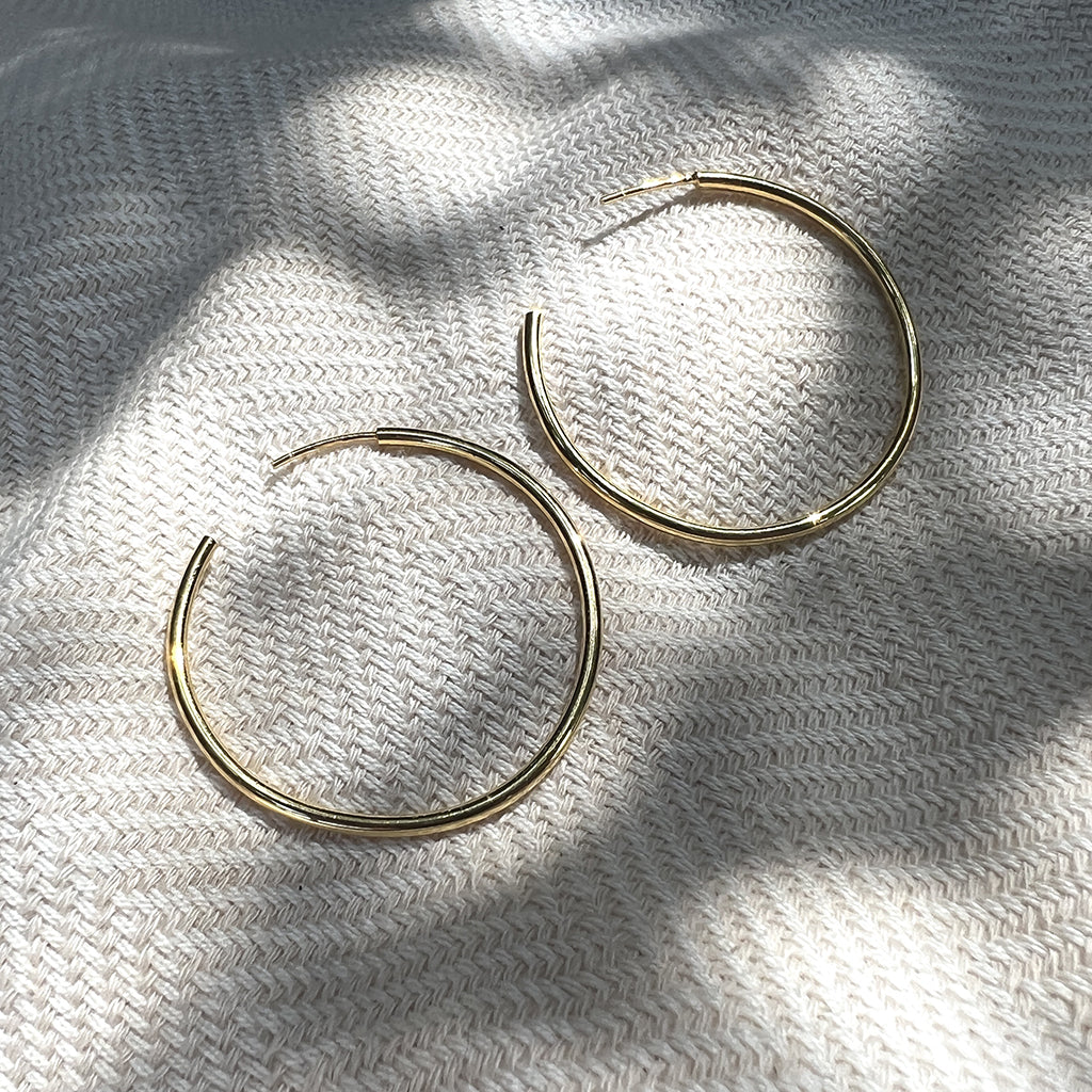 Classic Bombshell Hoop Earrings handcrafted from recycled materials with gold plating, showcasing elegance and sustainability.