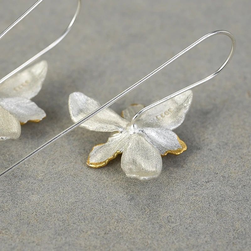 A pair of Daffodil Earrings featuring a delicate flower design, crafted from 925 sterling silver and 18K gold plating, showcasing elegance and sophistication.