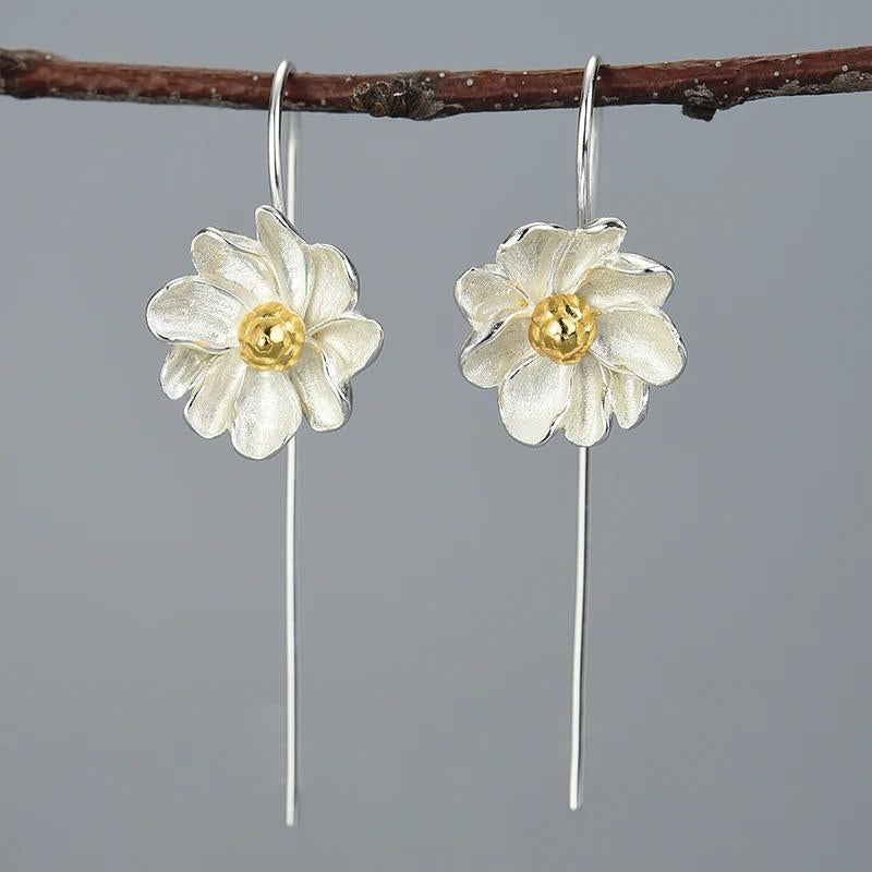 A pair of elegant silver earrings with intricate gold-plated floral designs, resembling delicate daisies, perfect for any occasion.