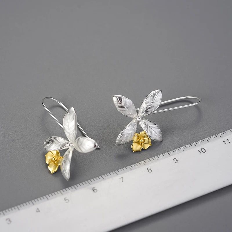 A pair of delicate flower earrings featuring daffodils crafted from polished sterling silver with warm 18K gold plating.