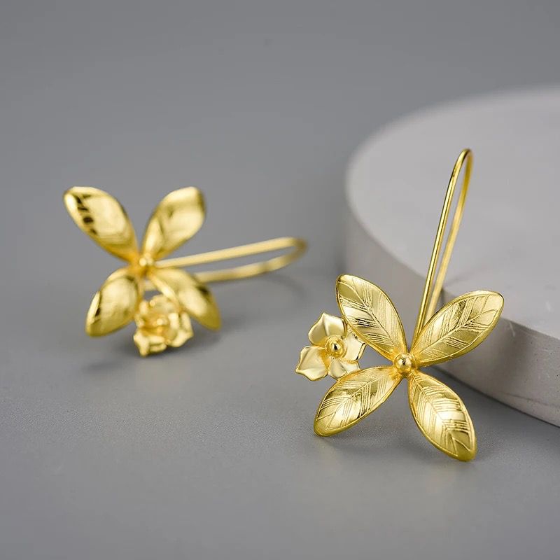 A pair of delicate flower earrings featuring daffodils crafted from polished sterling silver with warm 18K gold plating.