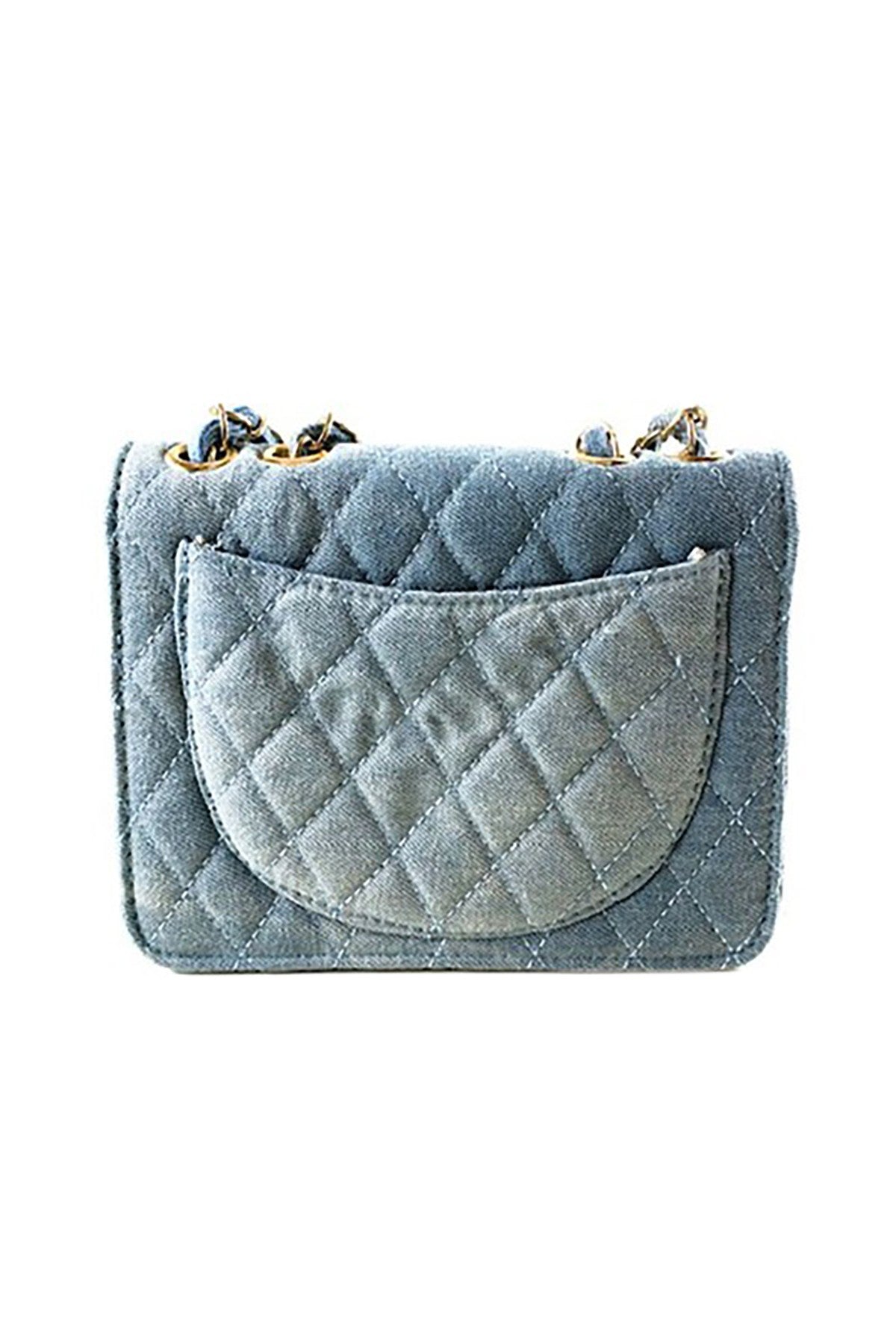 Stylish denim handbag with a flap and turn-lock closure, made from durable patent denim fabric.