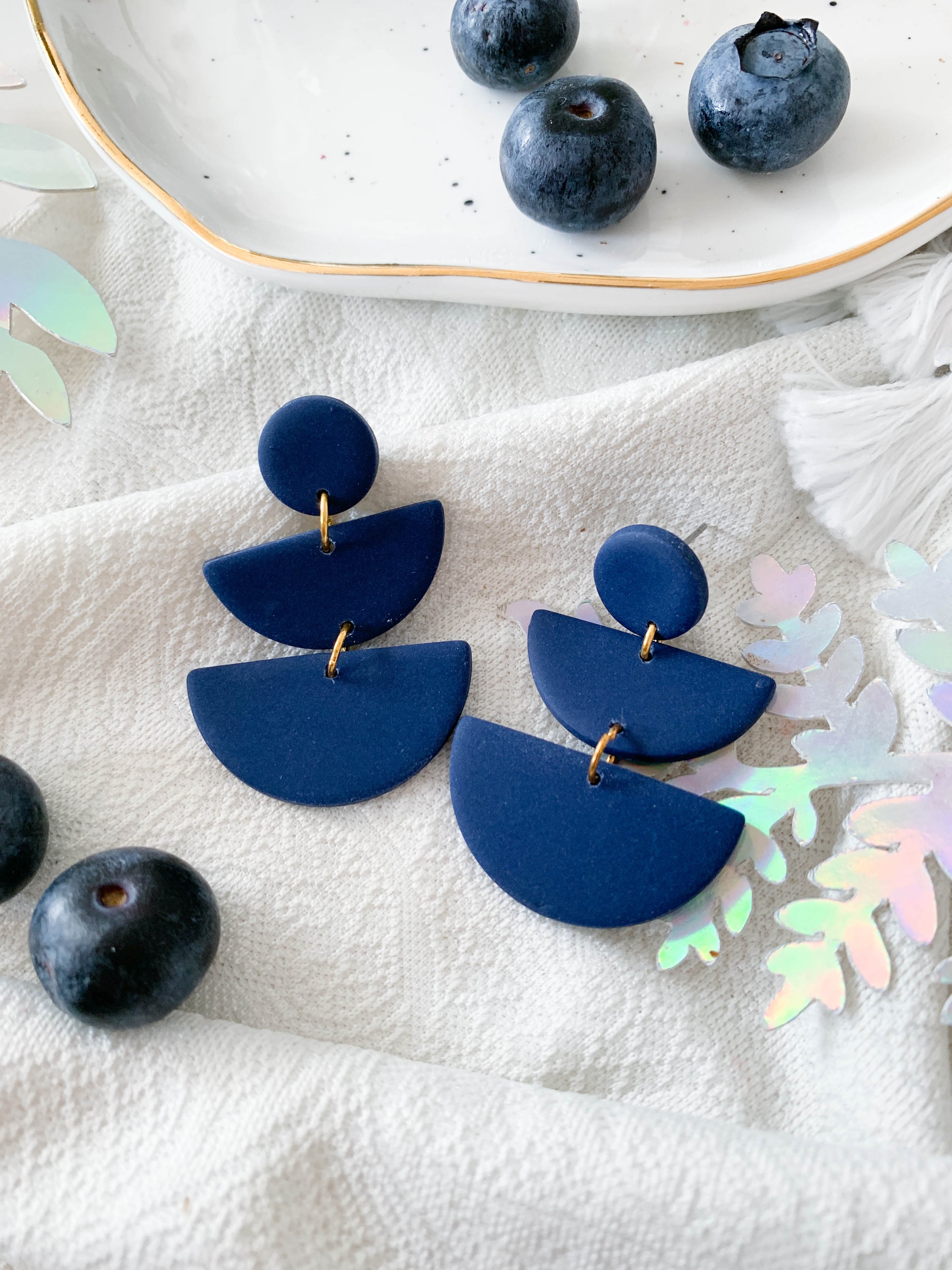 Emily Blueberry earrings featuring a navy semi-circle design, perfect for adding a whimsical touch to any outfit.