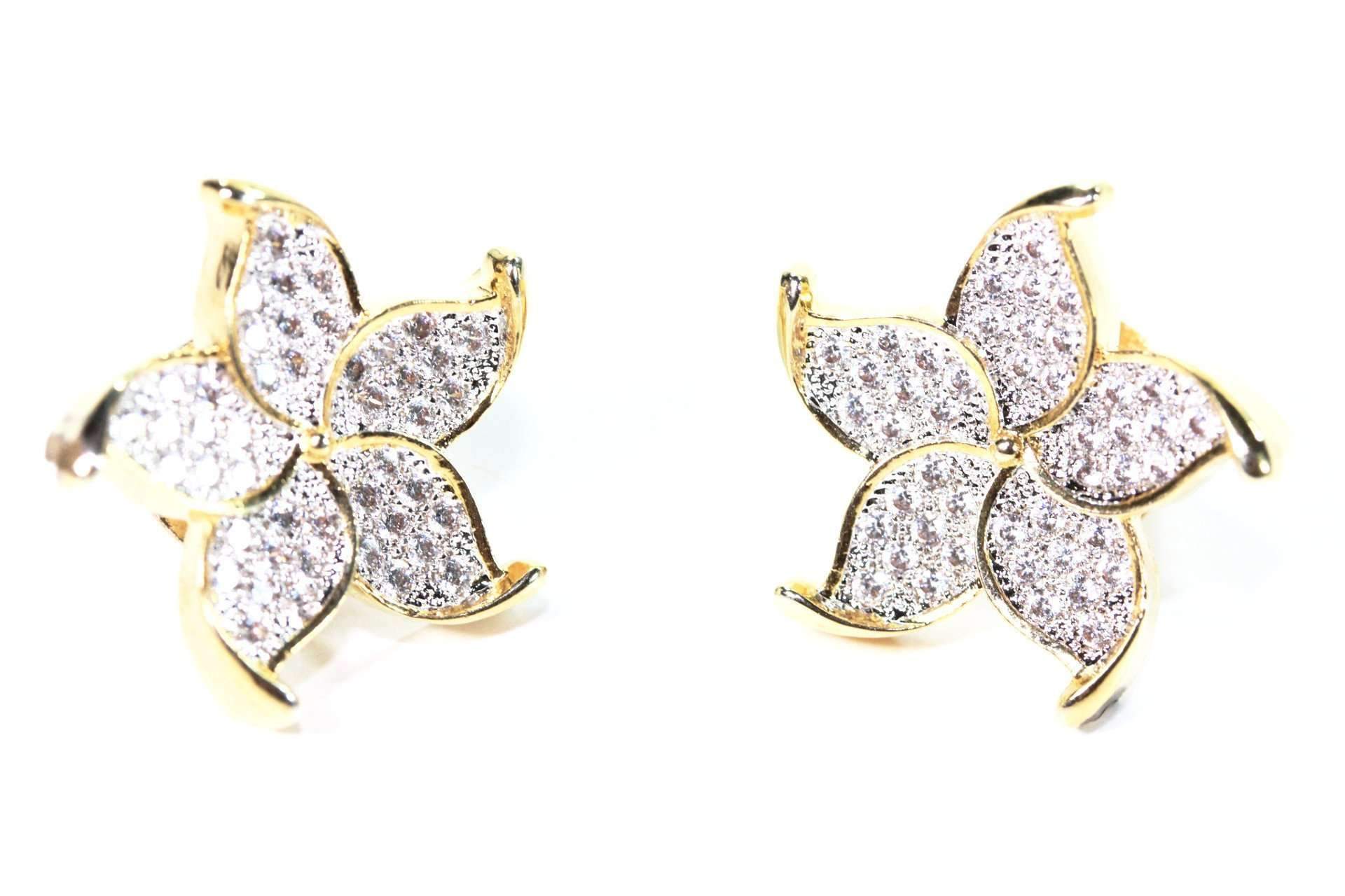 Elegant gold tone five petal flower stud earrings with shimmering cubic zirconias.