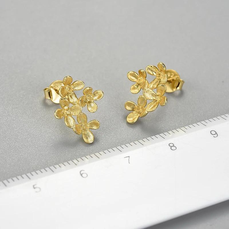 A pair of elegant Forget Me Not Earrings featuring three detailed flower clusters, crafted in 925 sterling silver with 18k gold plating.