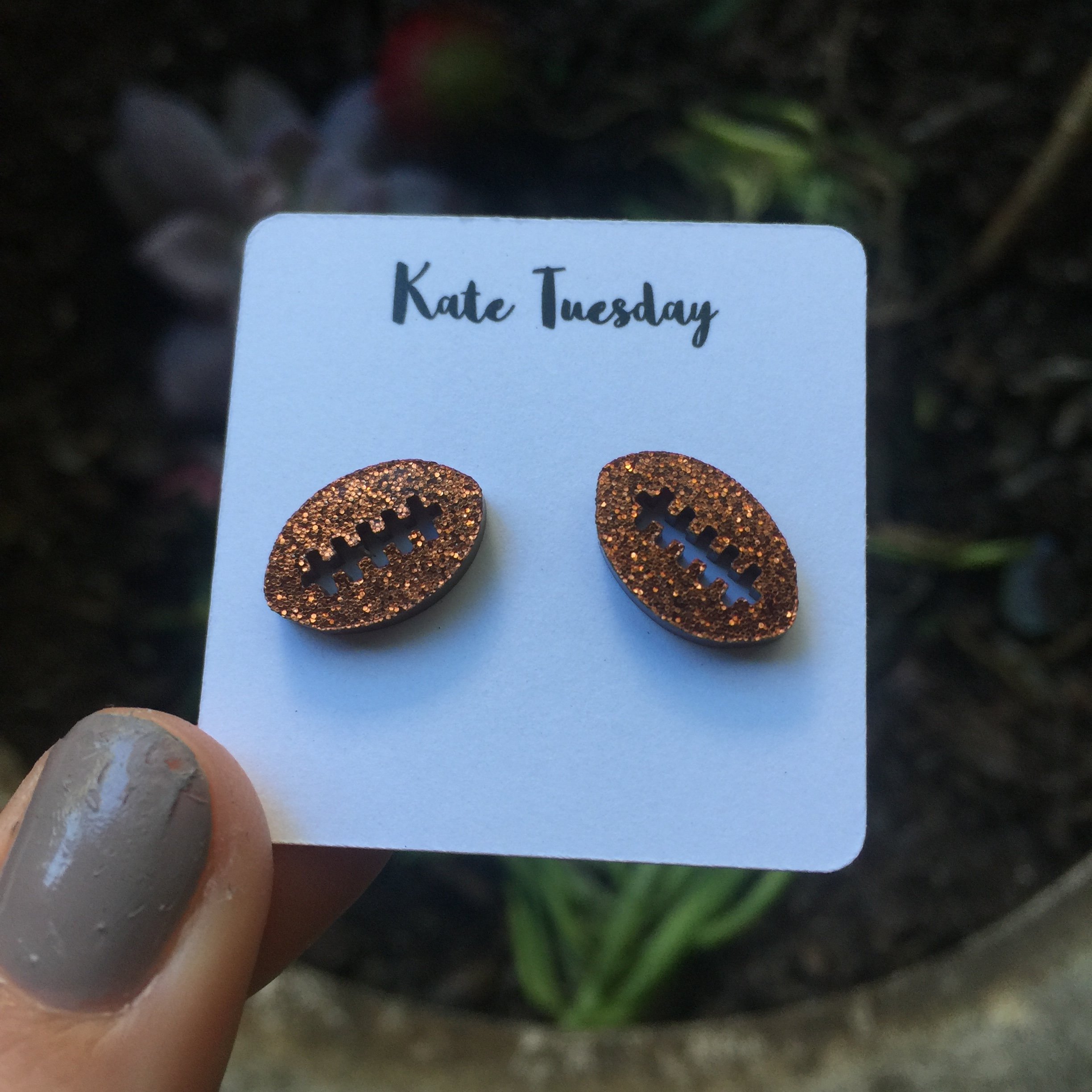 Football-themed copper sparkly stud earrings made of acrylic, showcasing a stylish and lightweight design.