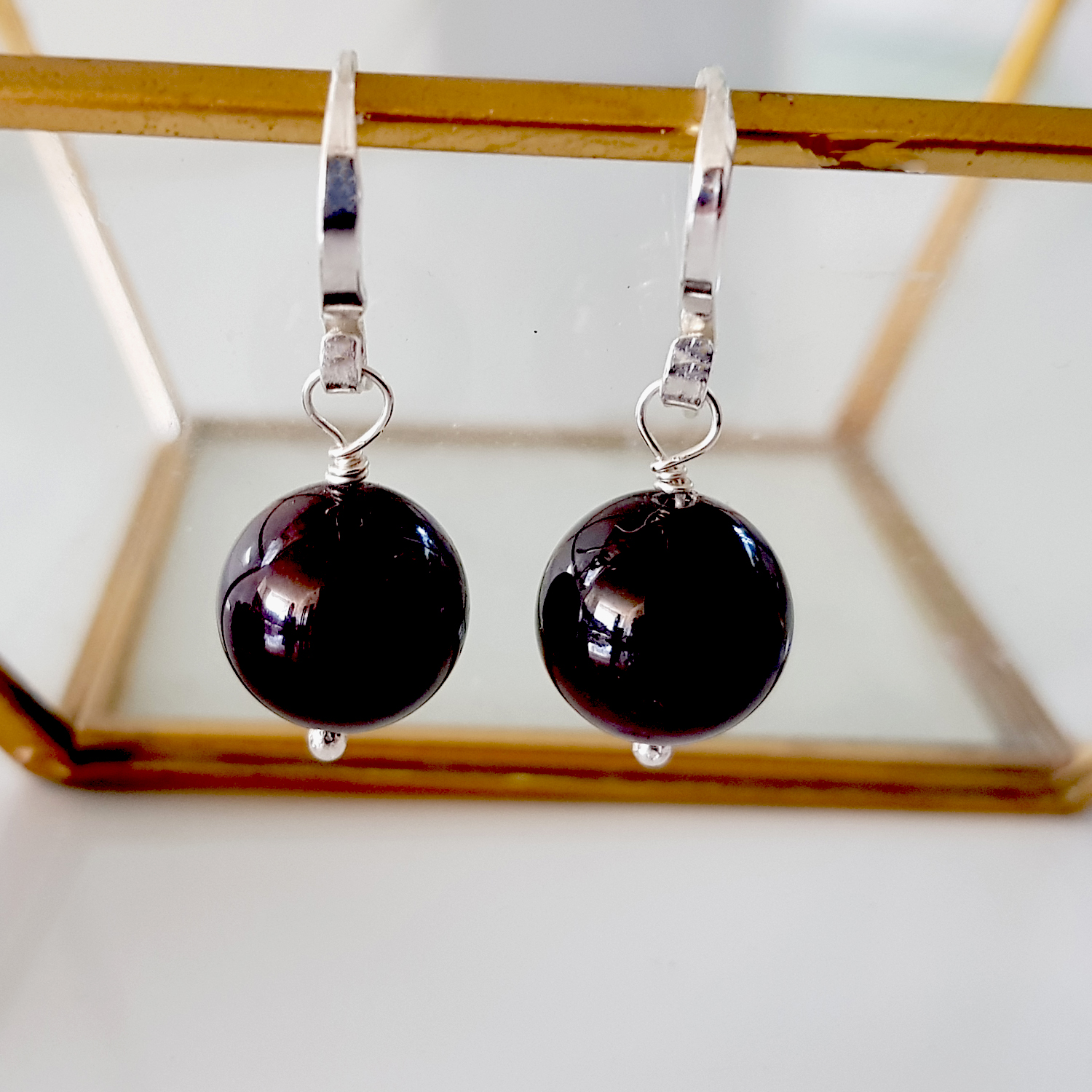 A pair of handmade Gem Ball Earrings featuring deep red garnet stones set in solid silver 925 French hooks, showcasing their elegant design.