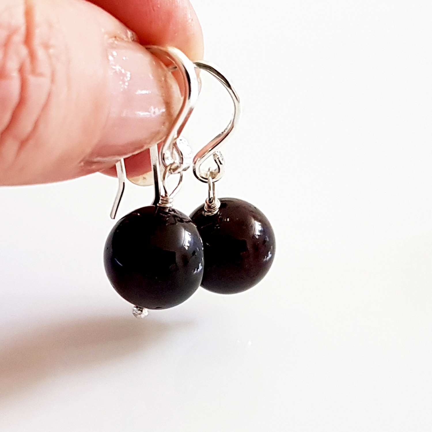 A pair of handmade Gem Ball Earrings featuring deep red garnet stones set in solid silver 925 French hooks, showcasing their elegant design.