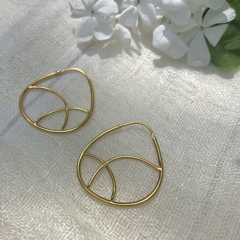 A pair of elegant geometric gold hoop earrings made from sterling silver and plated with 24K gold, showcasing a unique minimalist design.