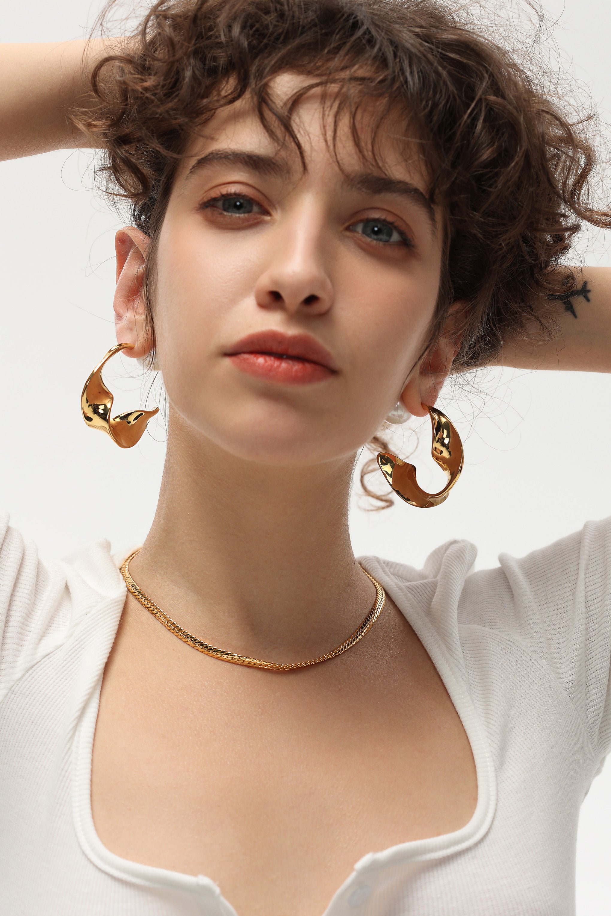 Gold Chunky Wave Hoop Earrings featuring a unique waved design and pearl accents, perfect for any occasion.