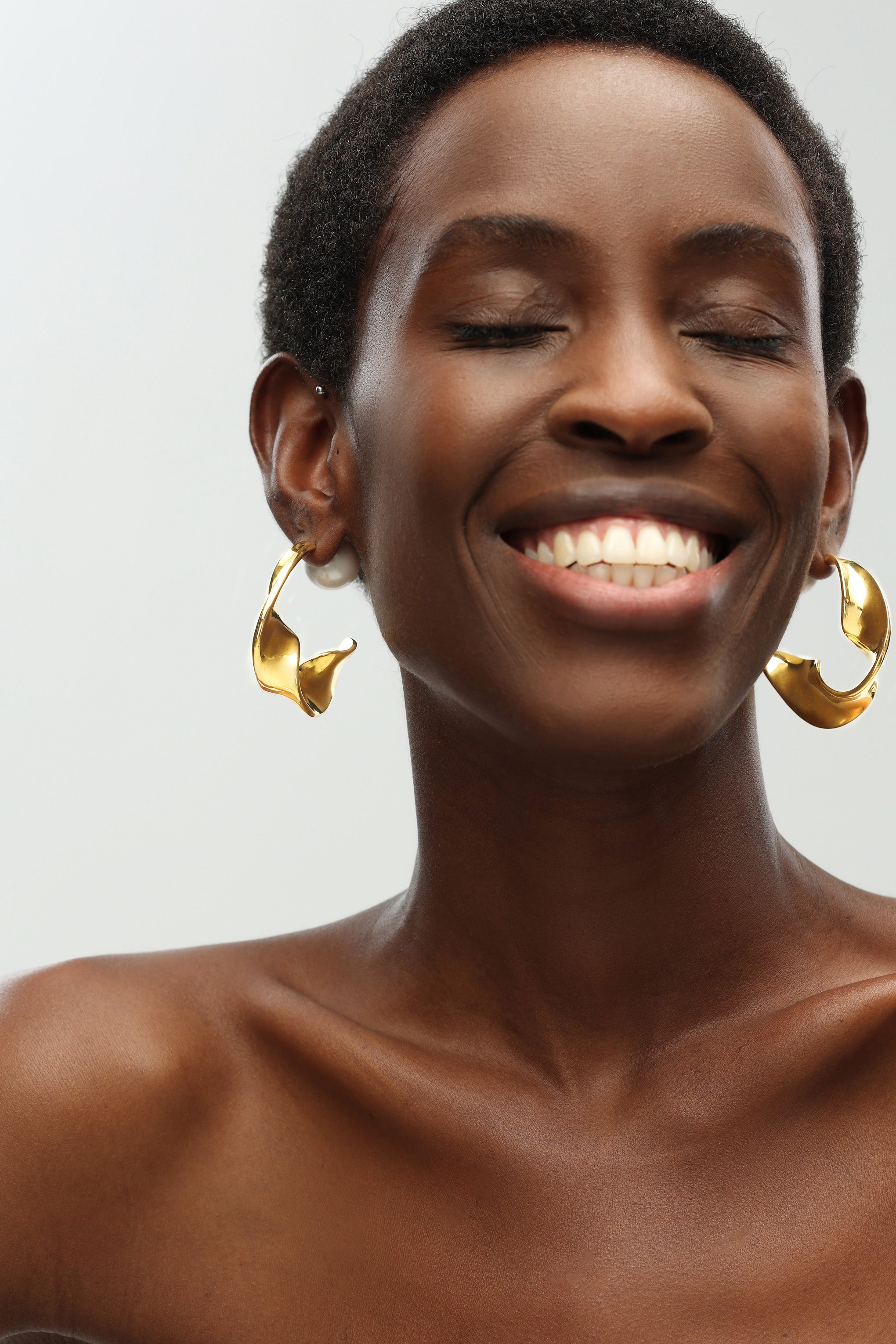 Gold Chunky Wave Hoop Earrings featuring a unique waved design and pearl accents, perfect for any occasion.