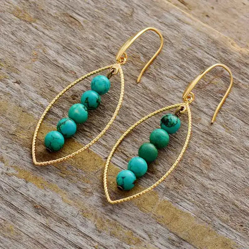 Elegant Gold Leaf Turquoise Dangle Earrings featuring vibrant turquoise stones and intricate gold leaf detailing.