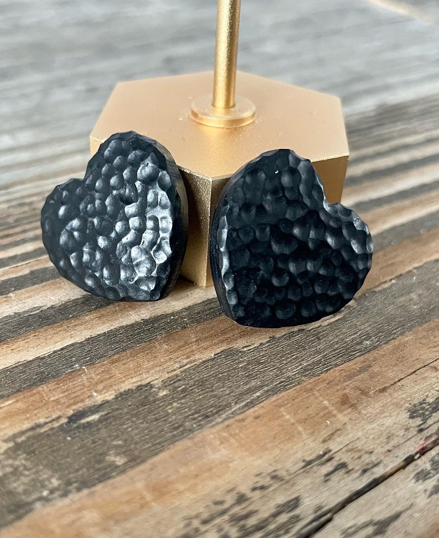 Handmade hammered black hearted stud earrings with unique texture and design, featuring stainless steel hooks for comfort.