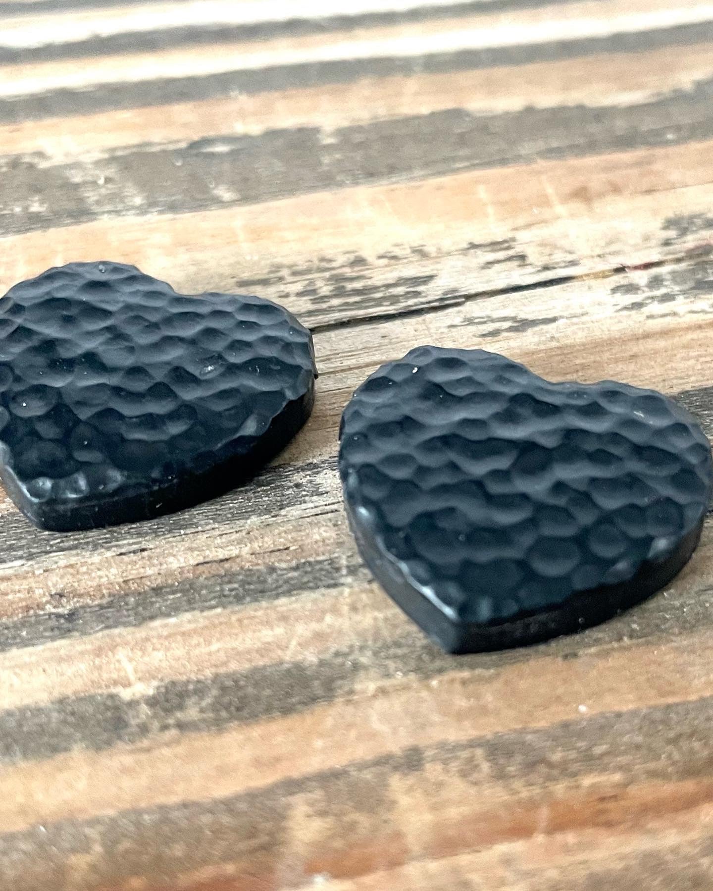 Handmade hammered black hearted stud earrings with unique texture and design, featuring stainless steel hooks for comfort.