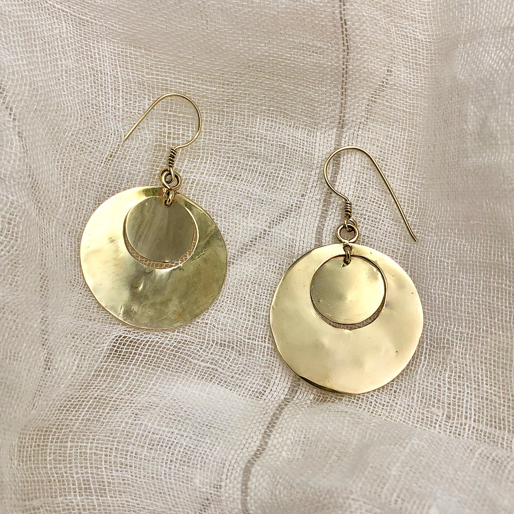 A pair of Hammered Circle Bombshell Earrings made from recycled brass, showcasing a unique hammered design with a polished finish.