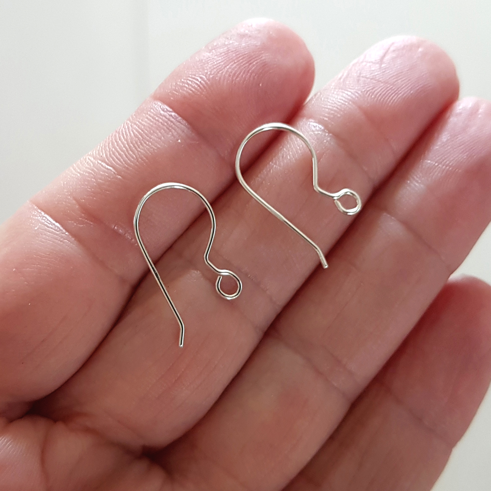 A pair of handcrafted fish hook ear wires made from Sterling Silver 925, featuring a simple loop design for easy wear and comfort.