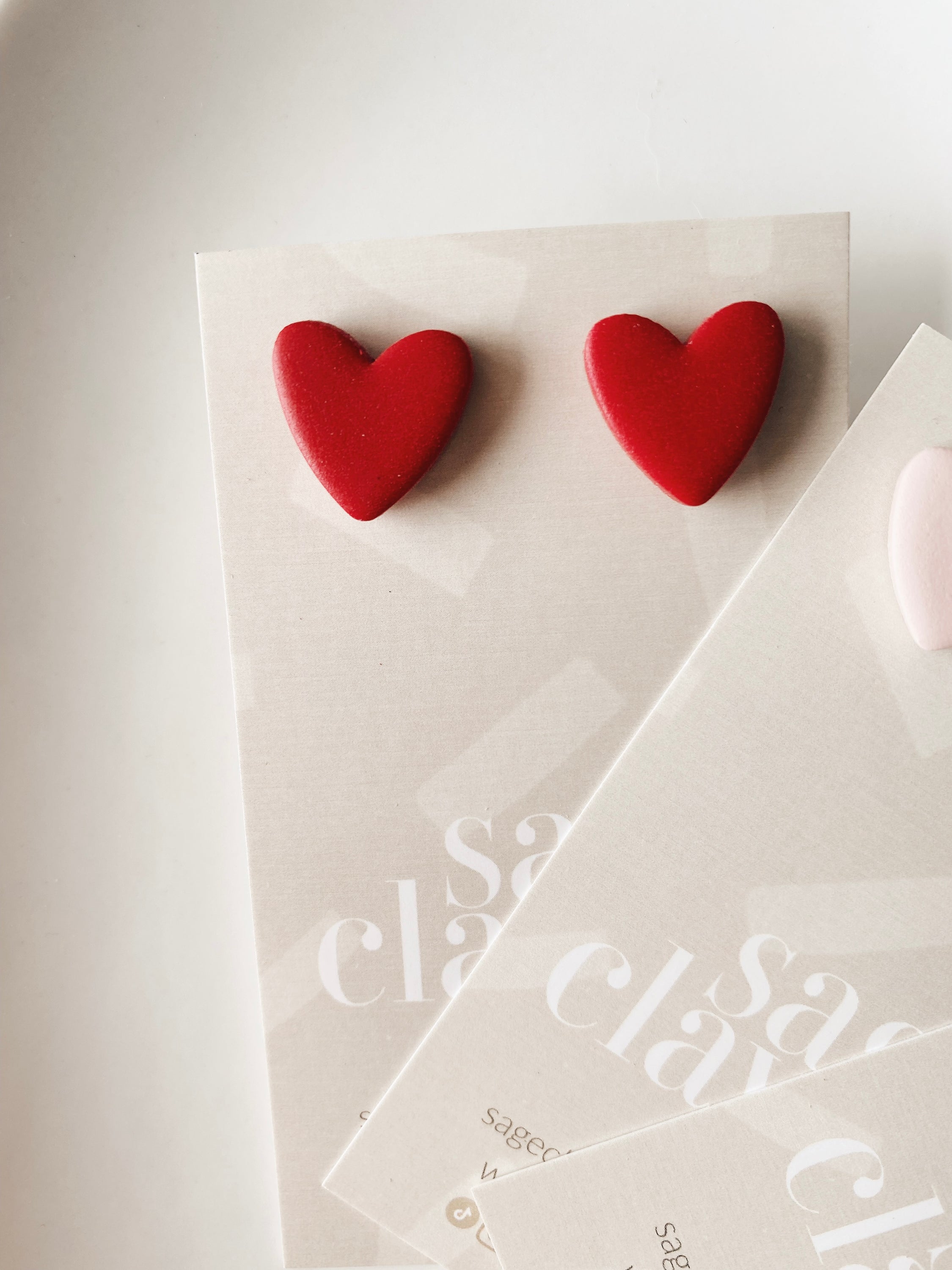 Handmade polymer clay heart studs earrings in vibrant colors, lightweight and hypoallergenic, perfect for everyday wear.