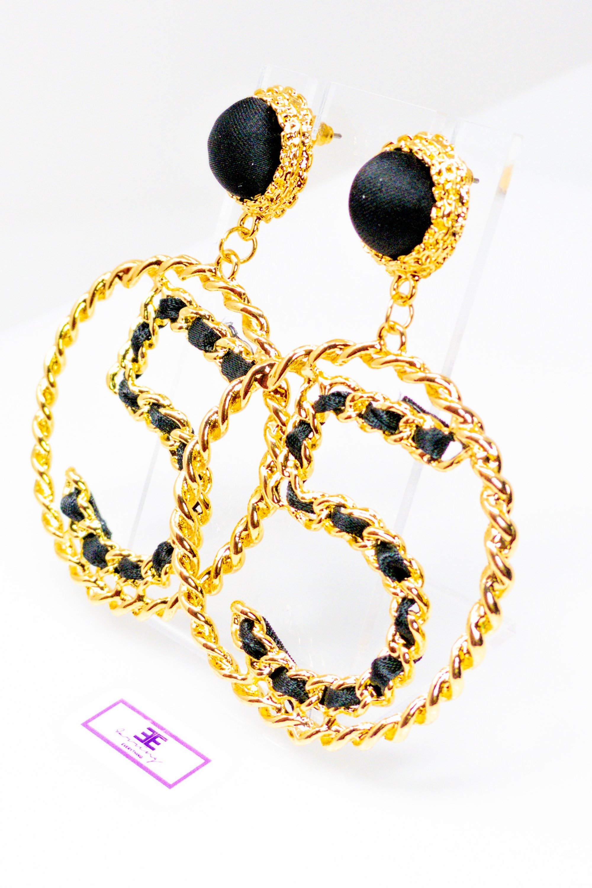 Elegant gold drop hoop earrings made from satin ribbon and brass, featuring a unique geometric design.