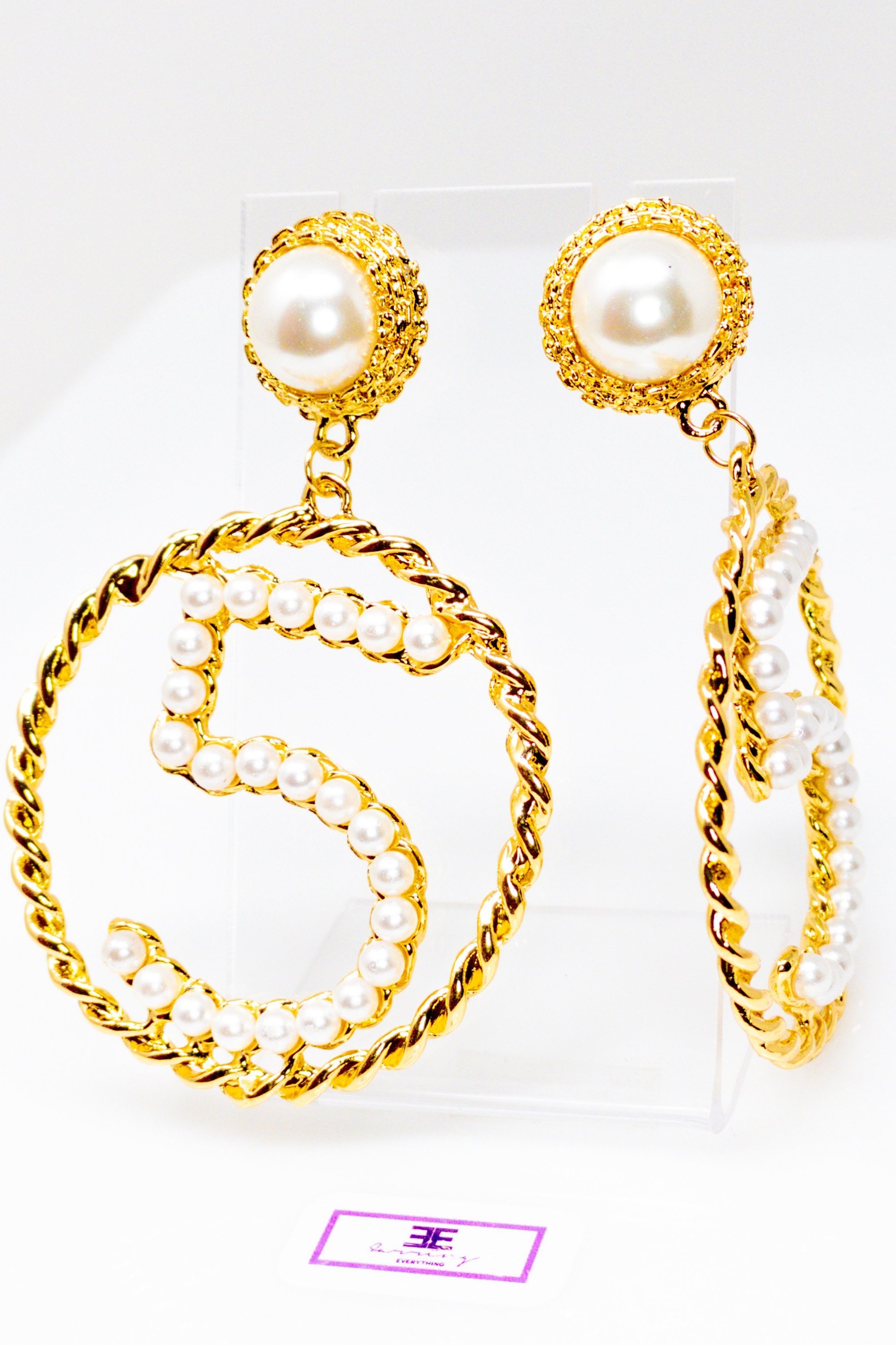 Elegant gold drop hoop earrings made from satin ribbon and brass, featuring a unique geometric design.