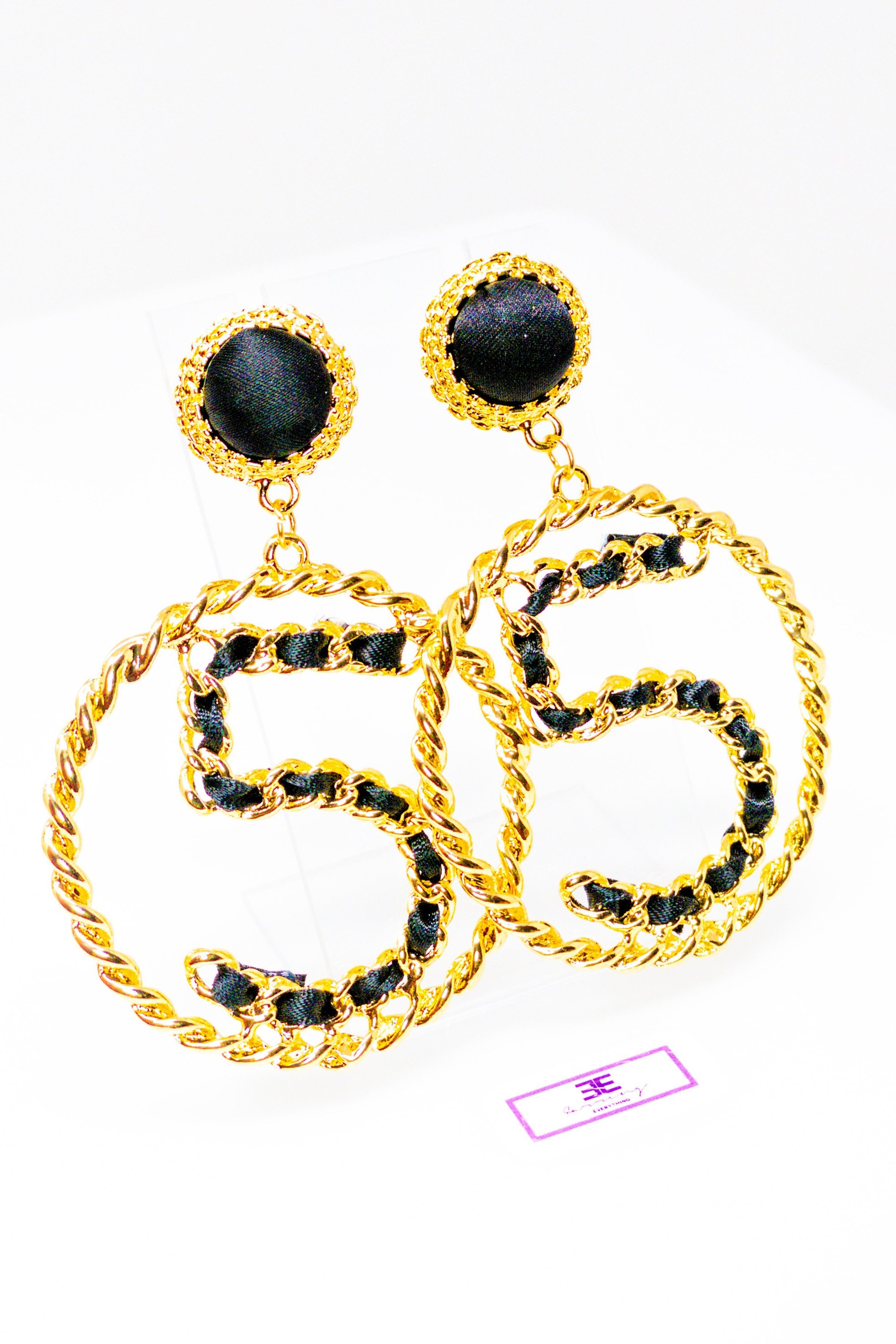 Elegant gold drop hoop earrings made from satin ribbon and brass, featuring a unique geometric design.