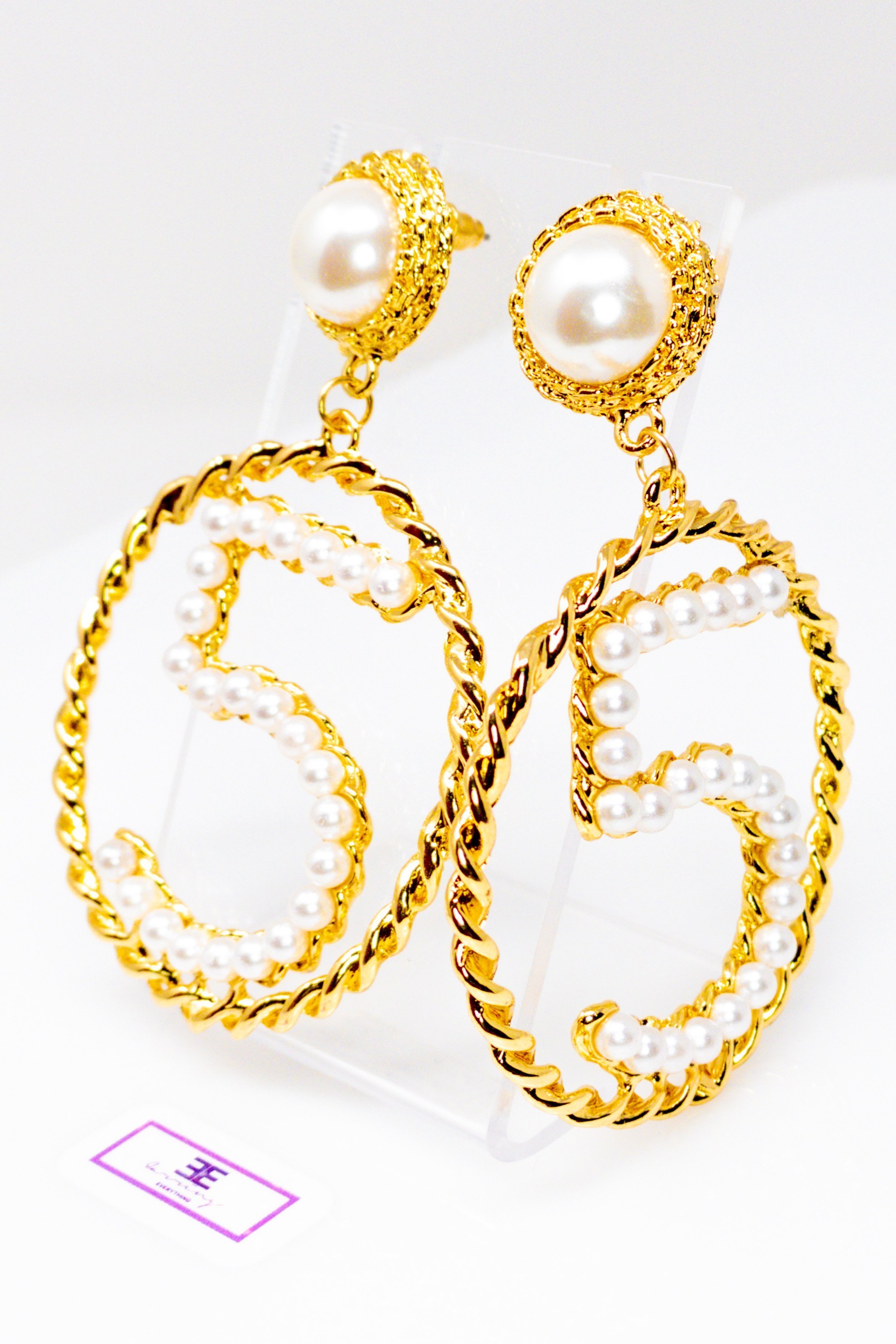 Elegant gold drop hoop earrings made from satin ribbon and brass, featuring a unique geometric design.