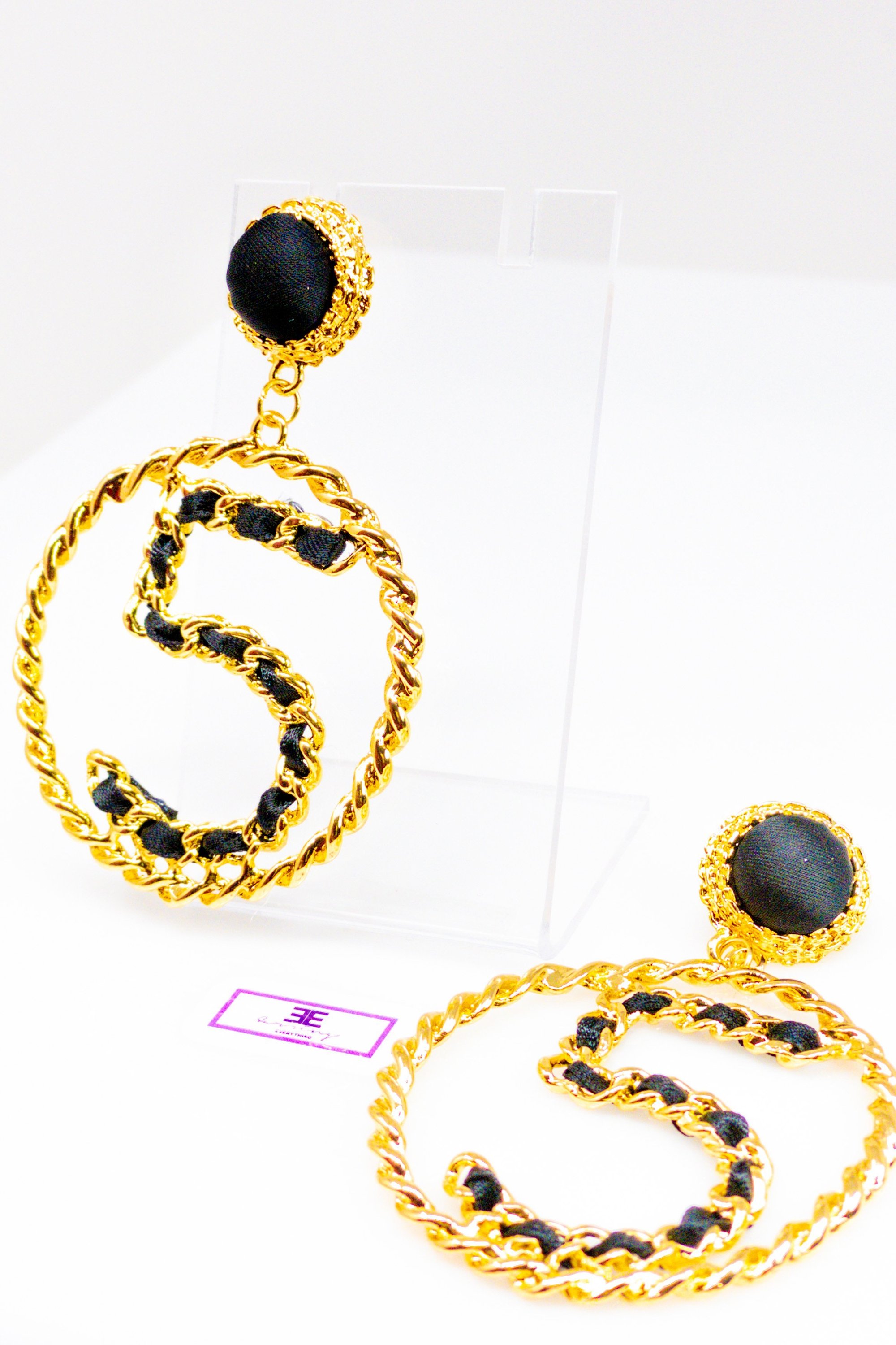 Elegant gold drop hoop earrings made from satin ribbon and brass, featuring a unique geometric design.